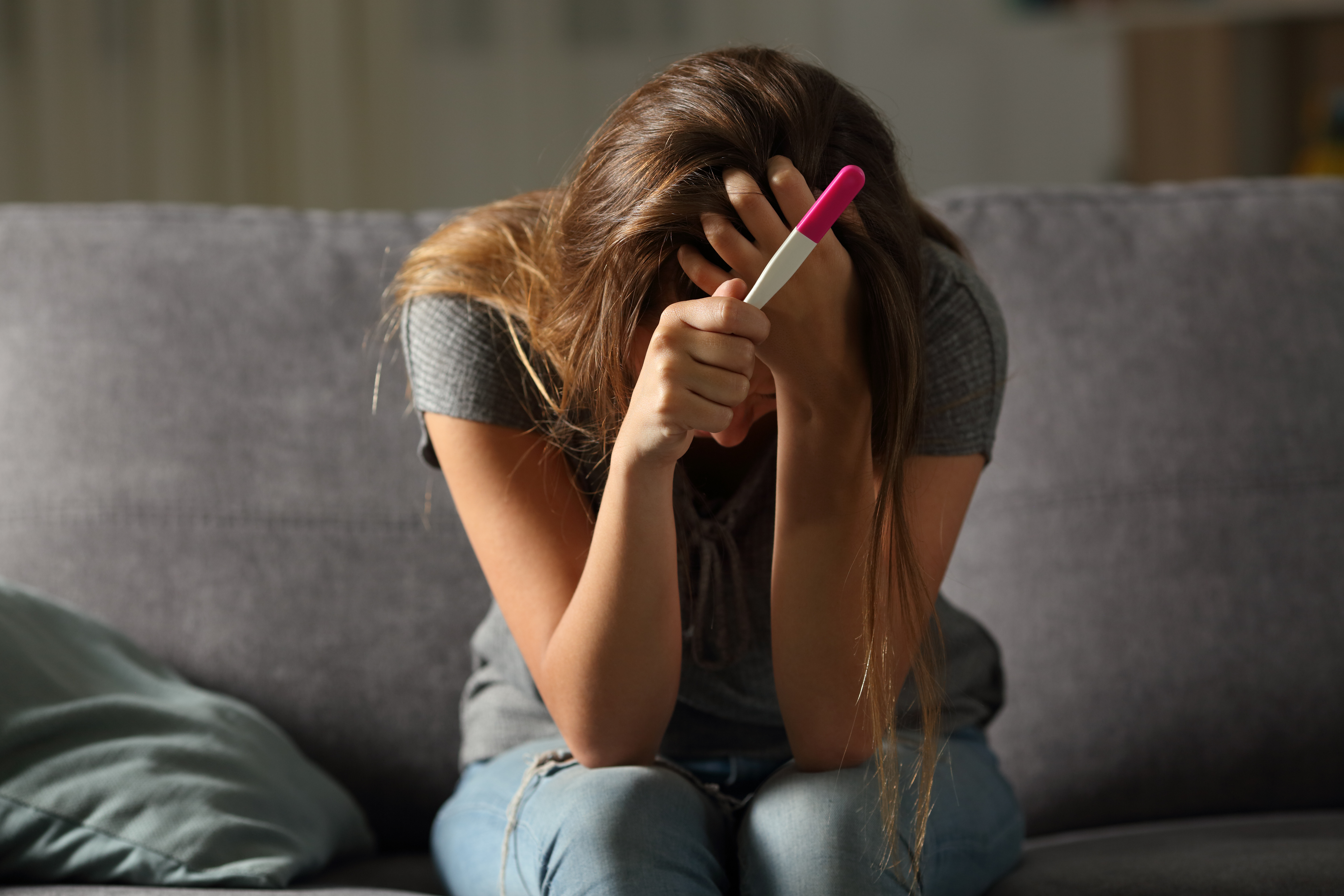 A sad woman holding a pregnancy test | Source: Shutterstock