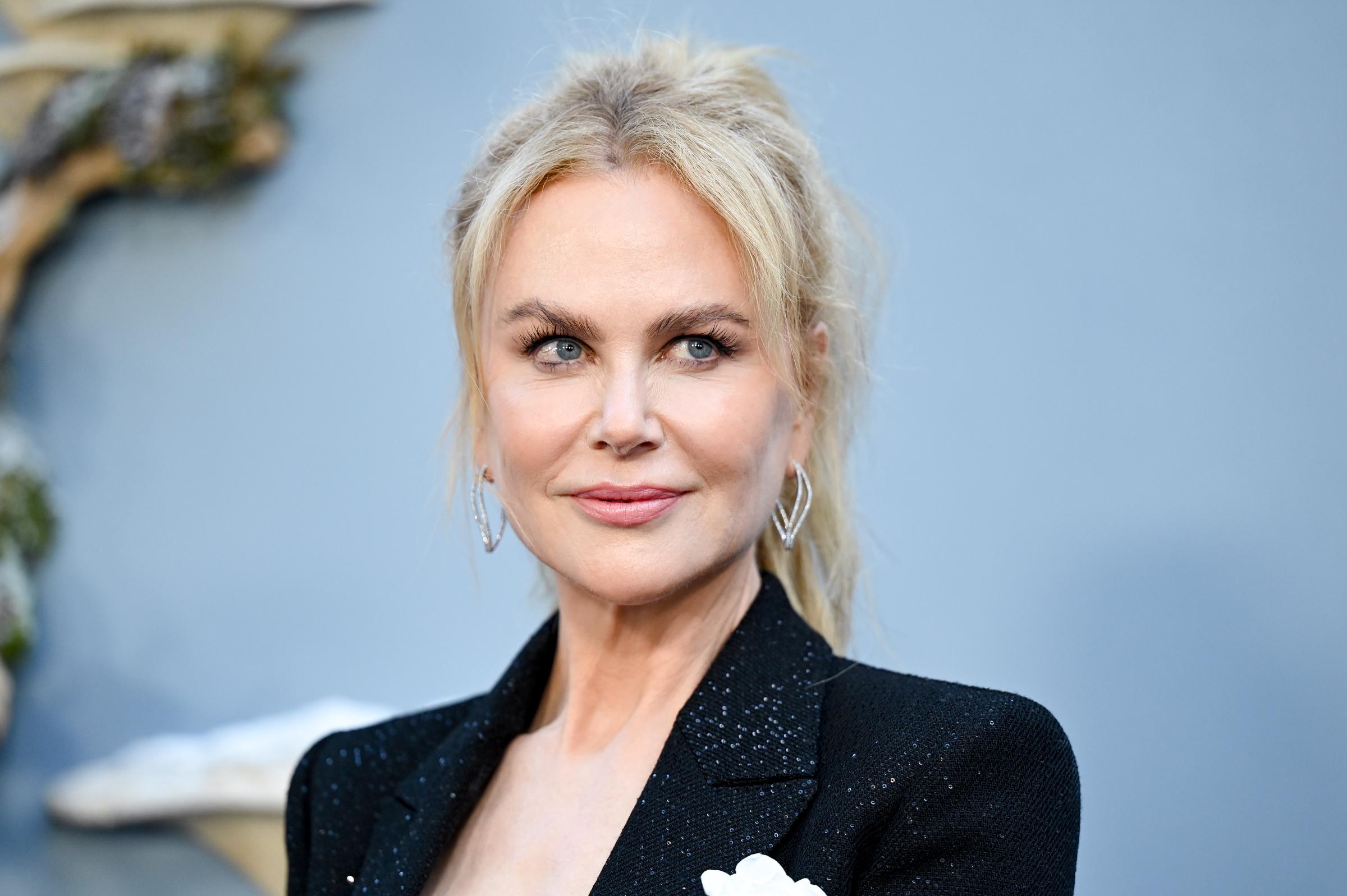 Nicole Kidman turns heads with an effortless glow, her diamond drop earrings catching the light as she poses for the cameras.