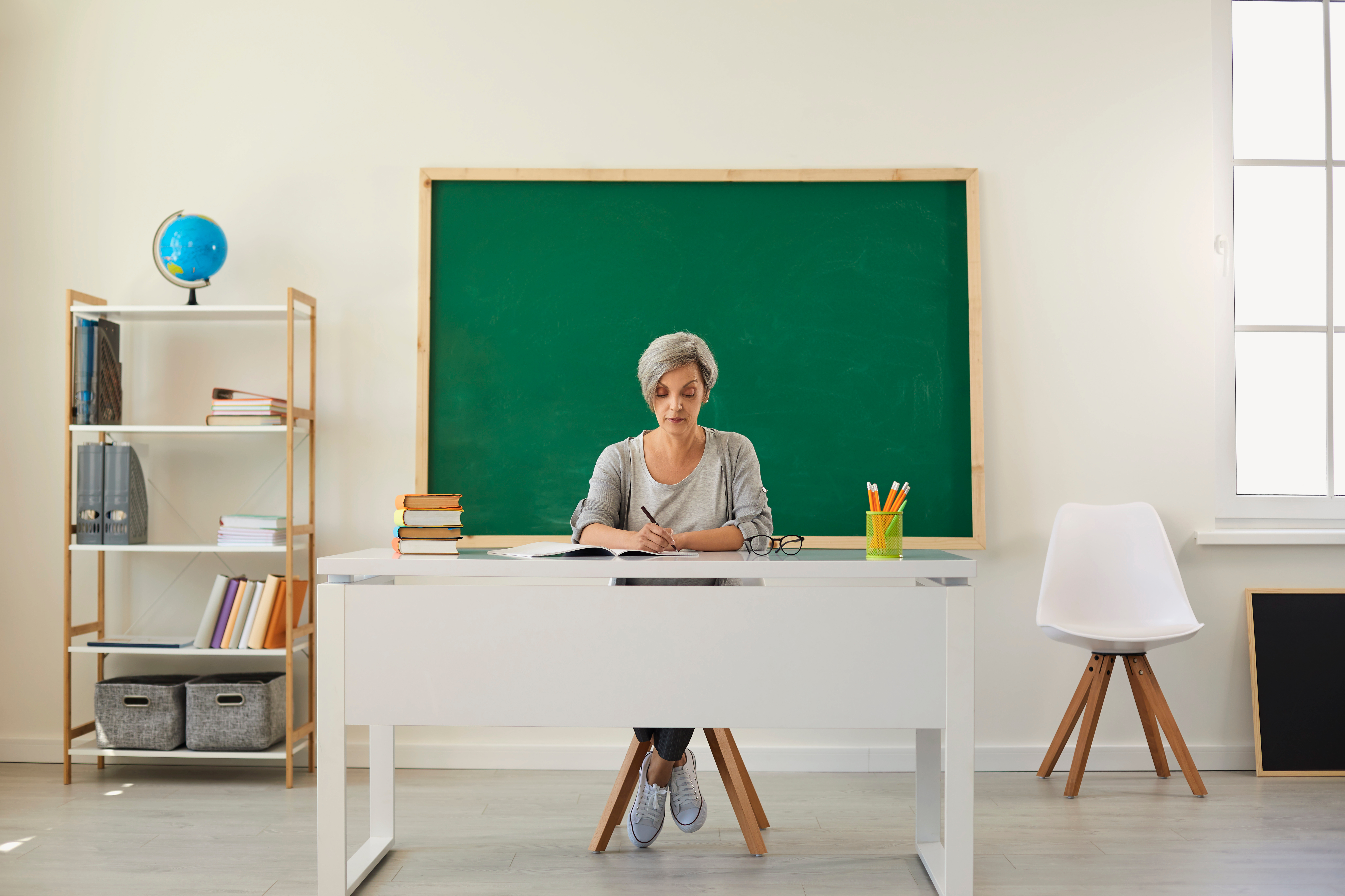 Teacher in an empty classroom | Source: Shutterstock