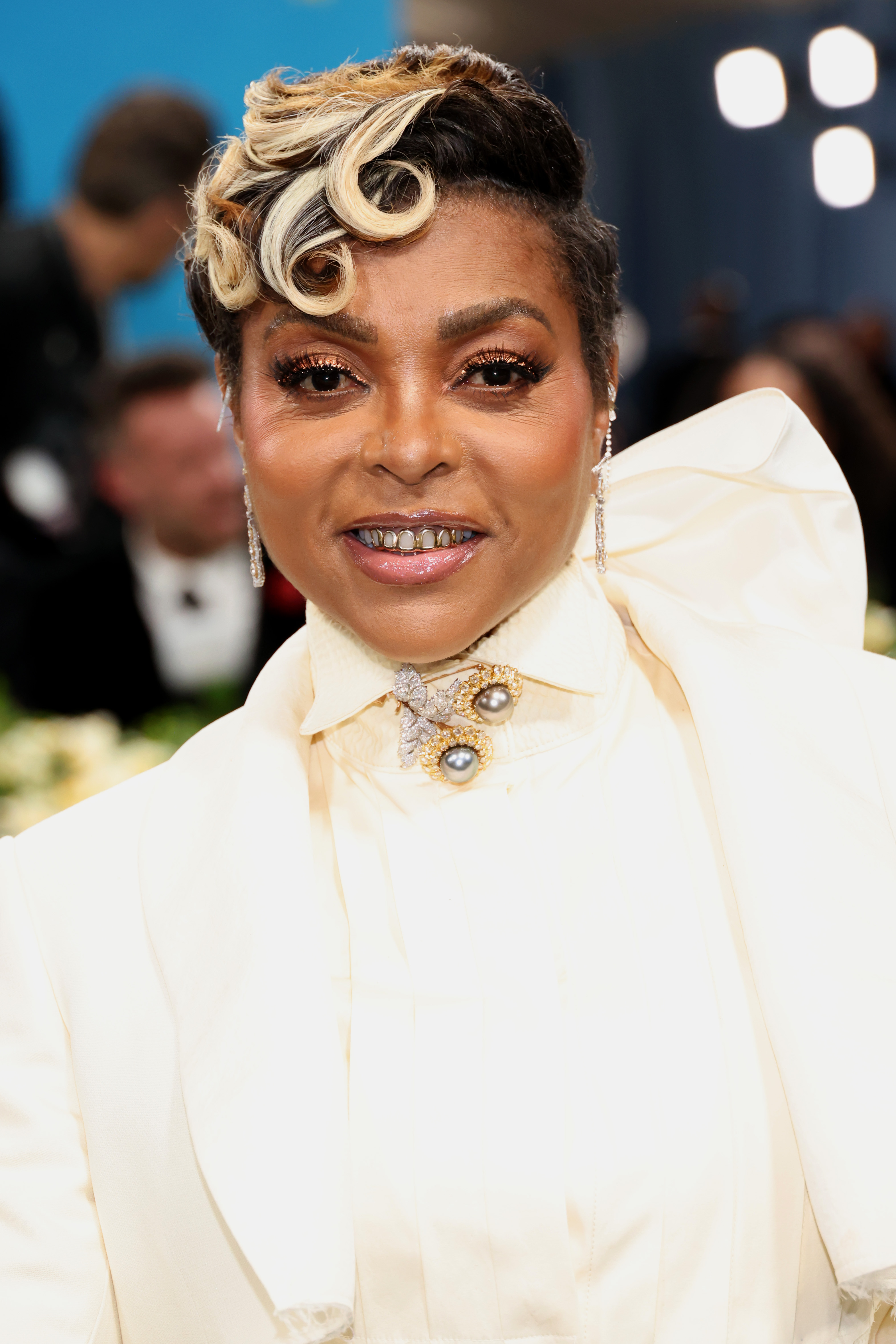 Taraji P. Henson attends The Met Gala celebrating "Superfine: Tailoring Black Style" at The Metropolitan Museum of Art wearing a structured ivory ensemble with a high neckline and dramatic shoulder detailing, captured in a close-up with her head slightly tilted and shoulders angled toward the lens.