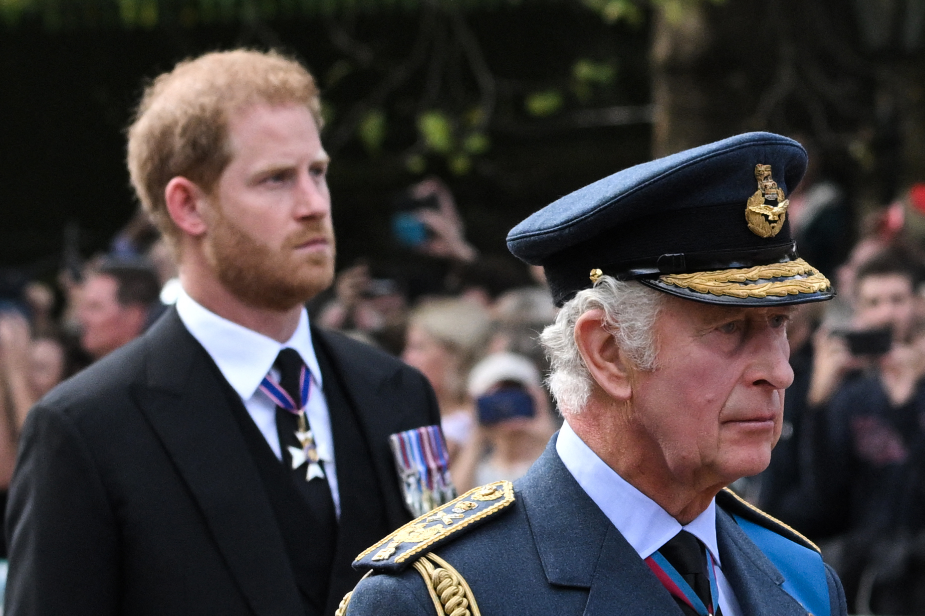 King Charles III and Prince Harry, Duke of Sussex walk behind the coffin of Queen Elizabeth II, adorned with a Royal Standard and the Imperial State Crown and pulled by a Gun Carriage of The King's Troop Royal Horse Artillery, during a procession from Buckingham Palace to the Palace of Westminster on 14 September 2022 in London, England. | Source: Getty Images