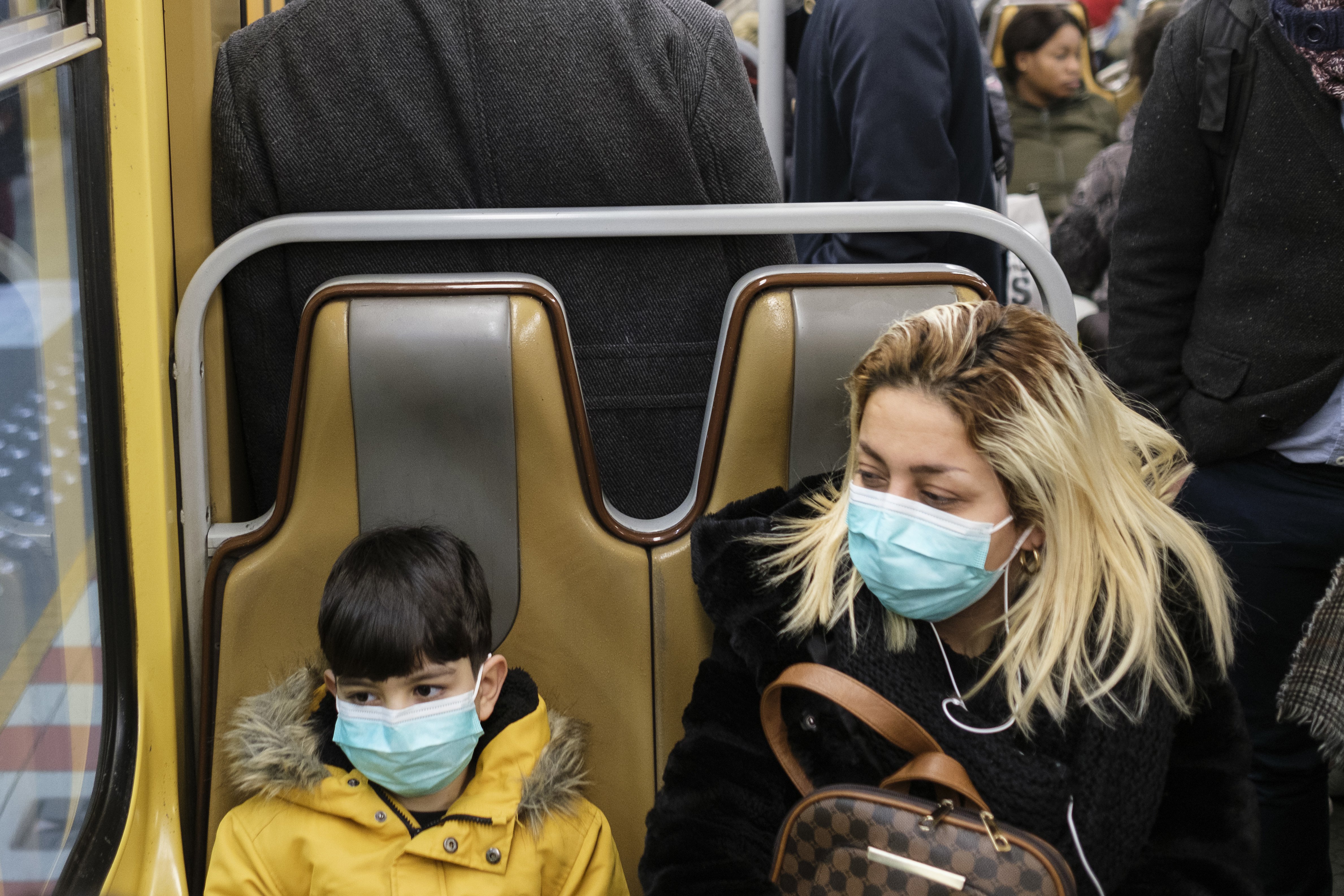 Una mujer y un niño usan máscaras protectoras en el sistema de trenes subterráneos el 03 de marzo de 2020 en Bruselas, Bélgica. | Foto: Getty Images