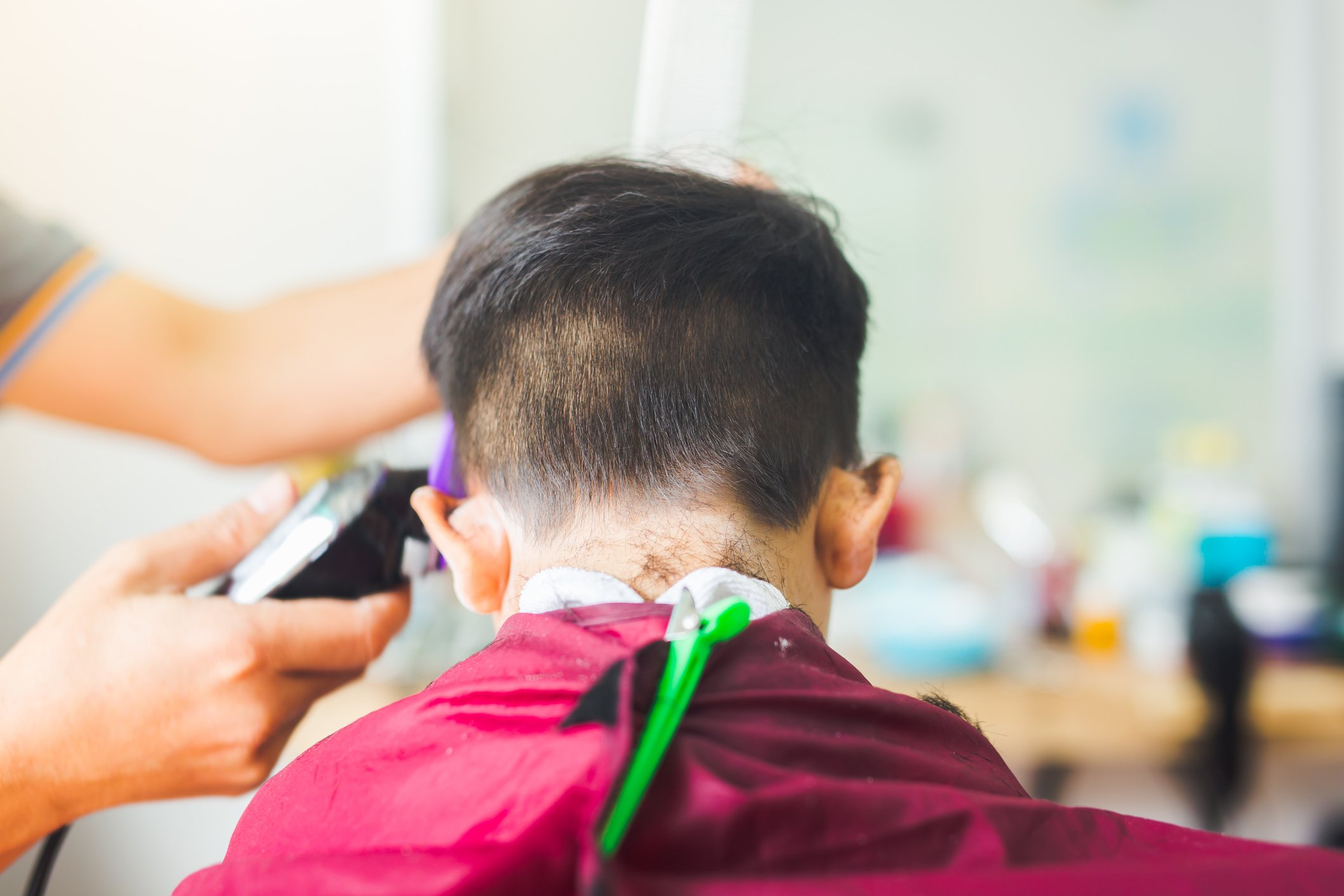 Rear View Of Boy Having Haircut In Barber Shop  | Photo: Getty Images
