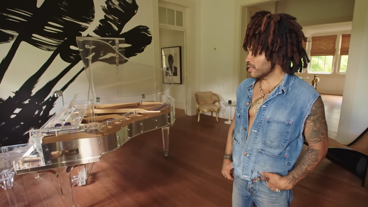 Lenny stands in the main house next to his rare Kawai Plexiglas grand piano, which once belonged to Hollywood actress Ingrid Bergman. | Source: YouTube/@Archdigest