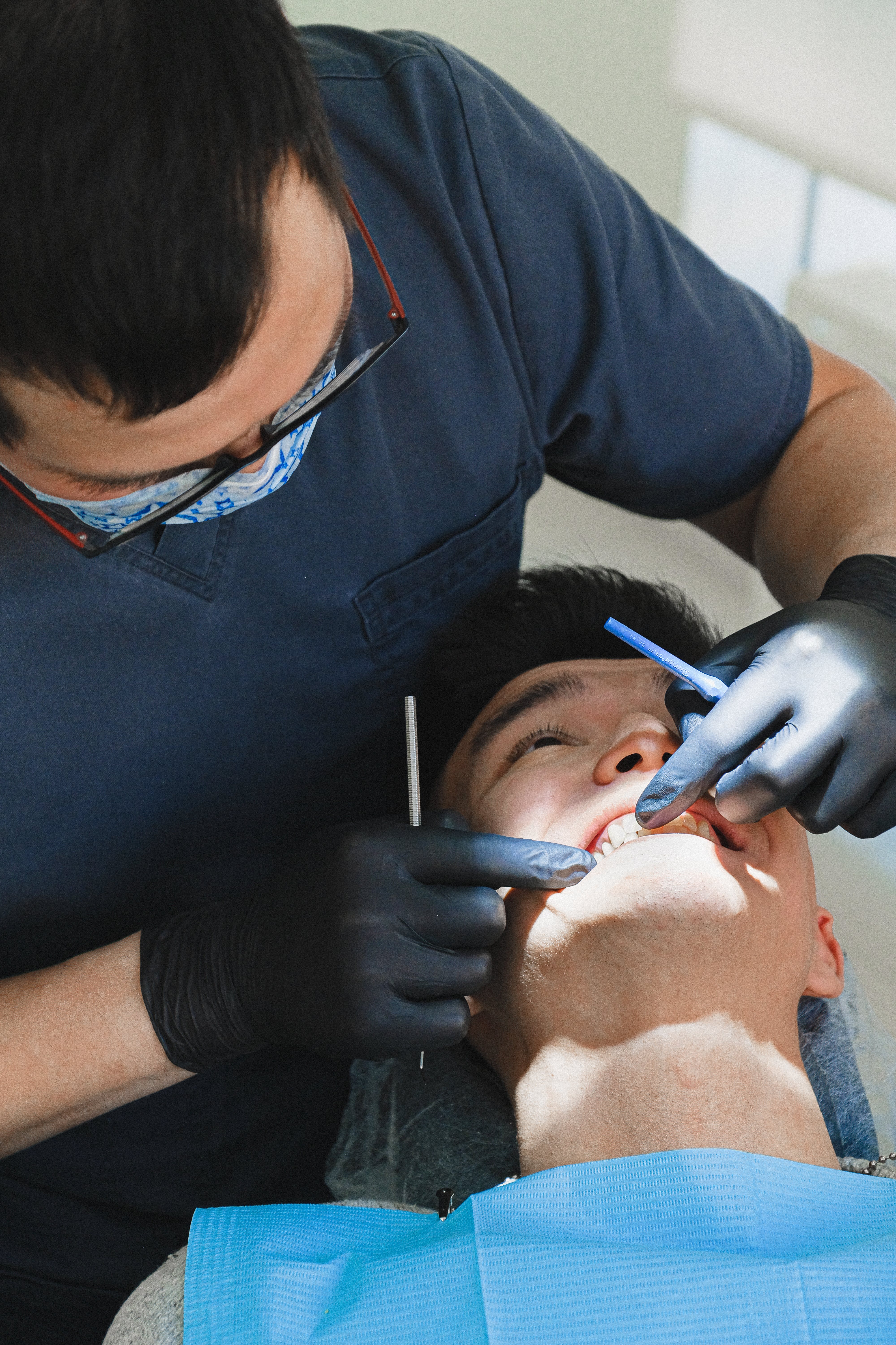 A male dentist examining a patient. | Source: Pexels