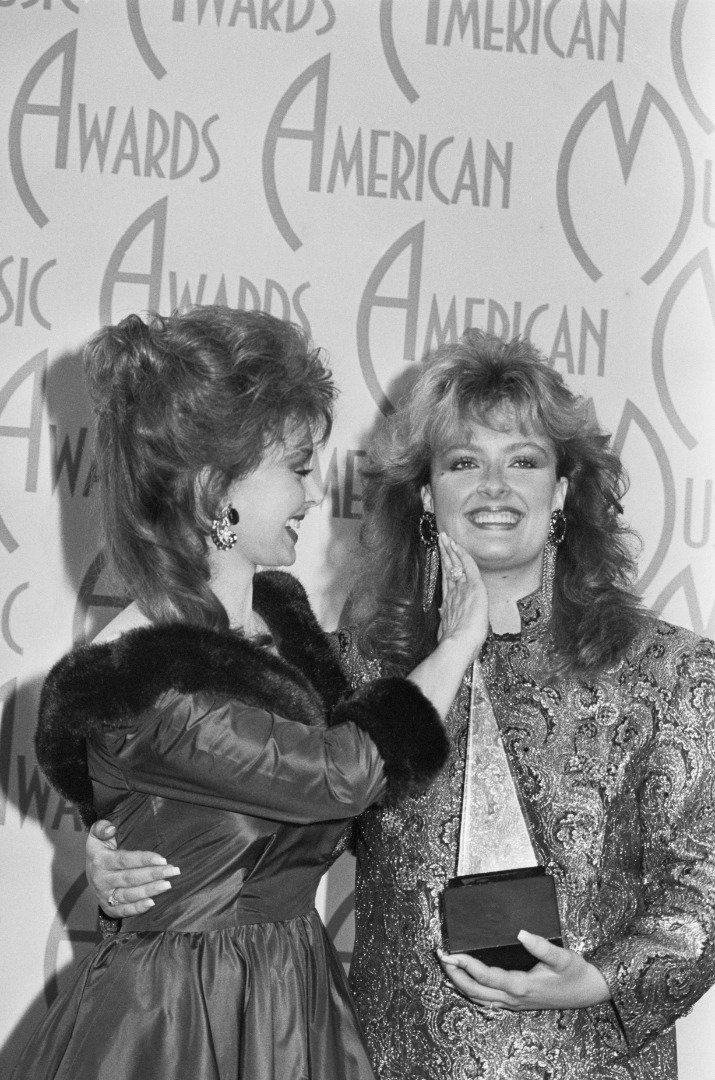 Mother-daughter singing duo the Judds embrace after winning Best Country Single at the 1987 American Music Awards. | Source: Getty Images