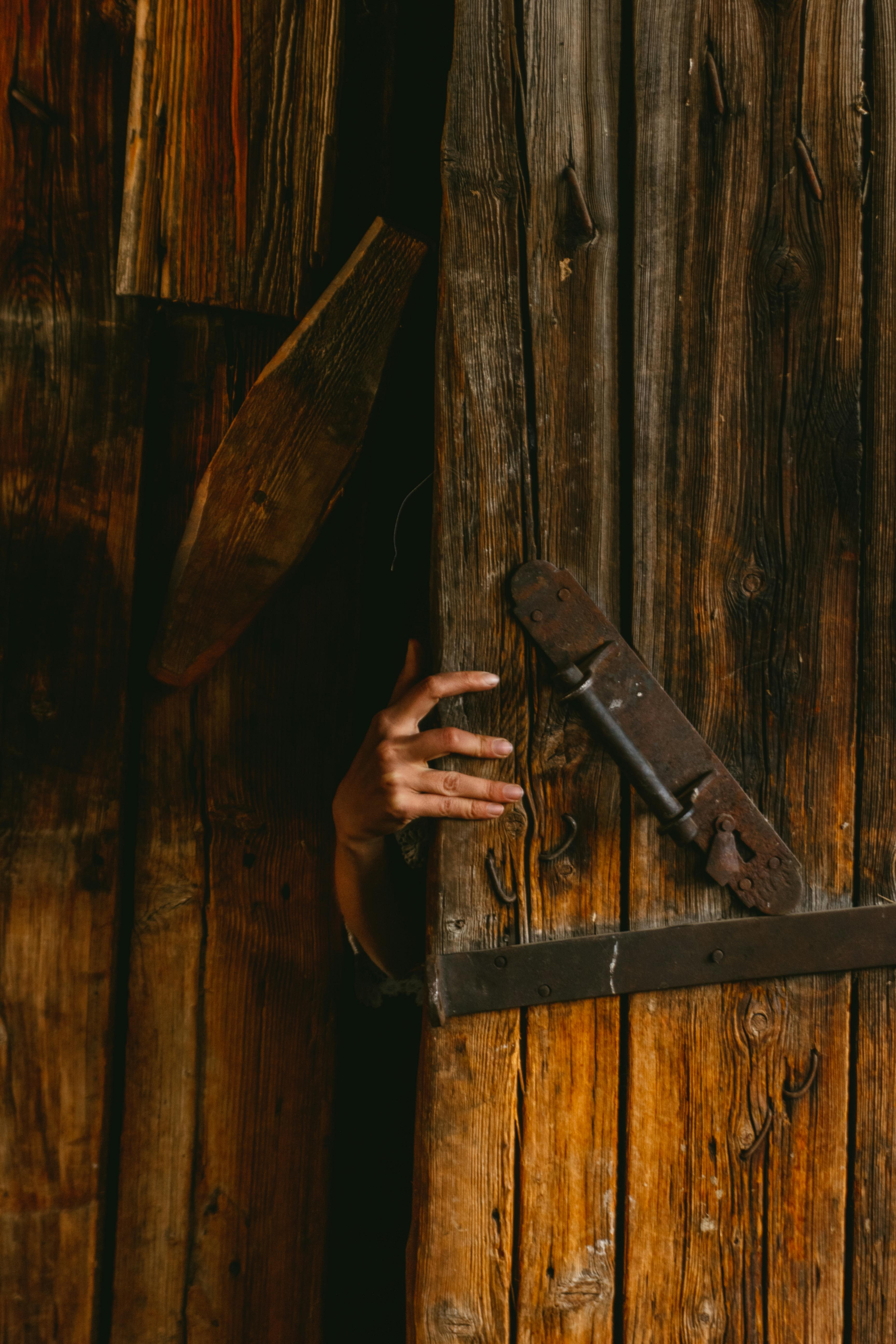 A hand opening a shed door | Source: Pexels