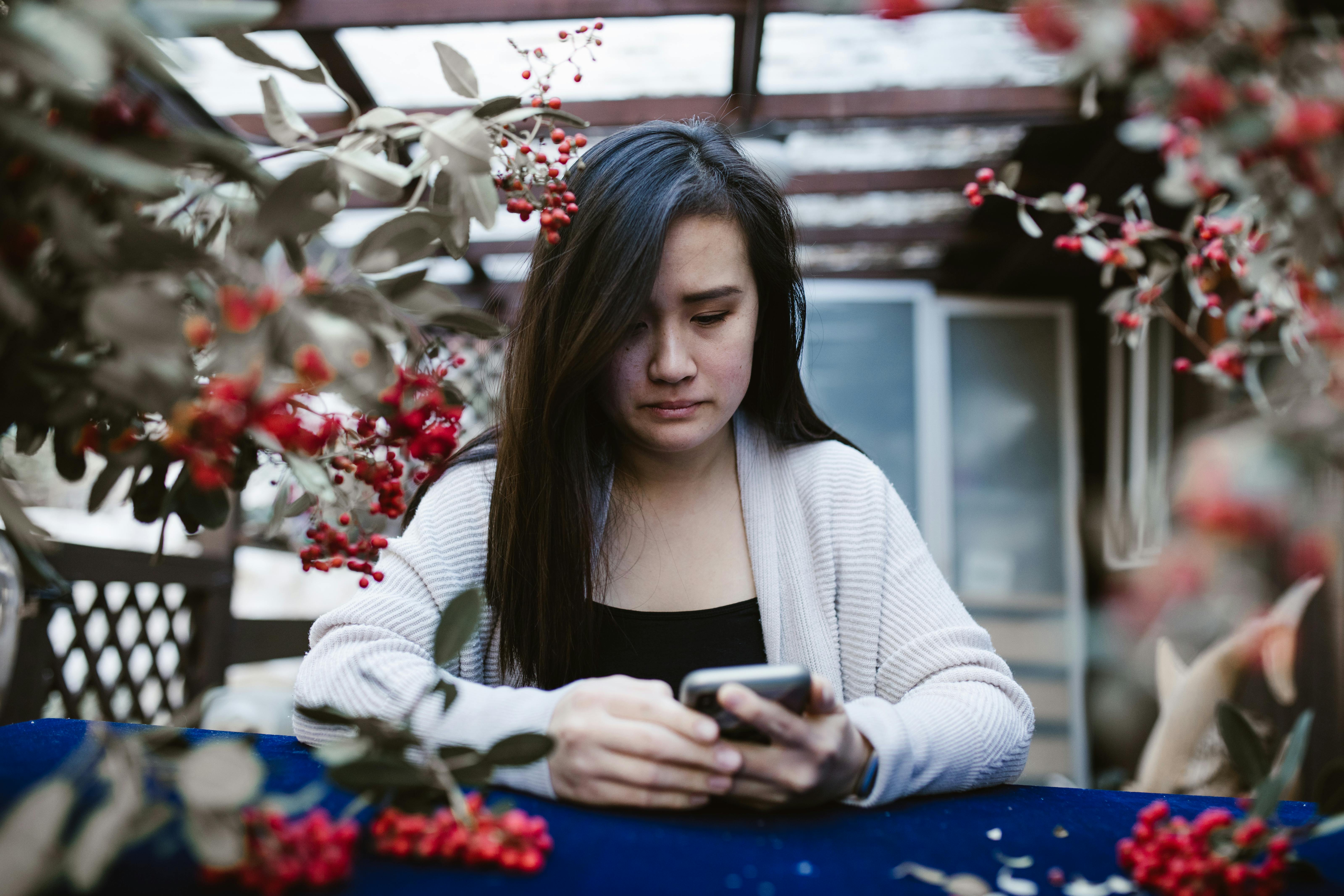 A sad woman looking at her phone | Source: Pexels