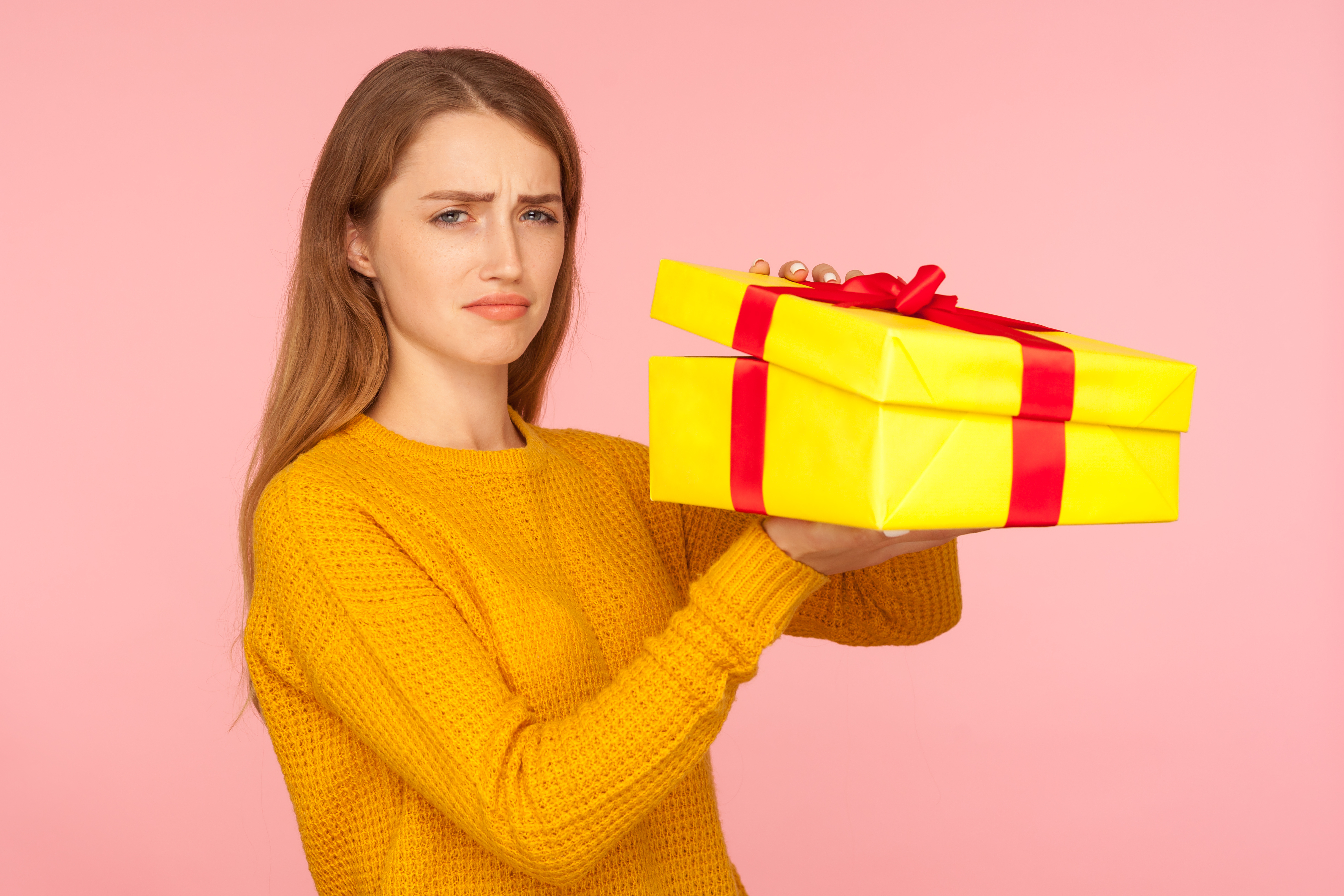A disappointed woman holding a gift | Source: Getty Images