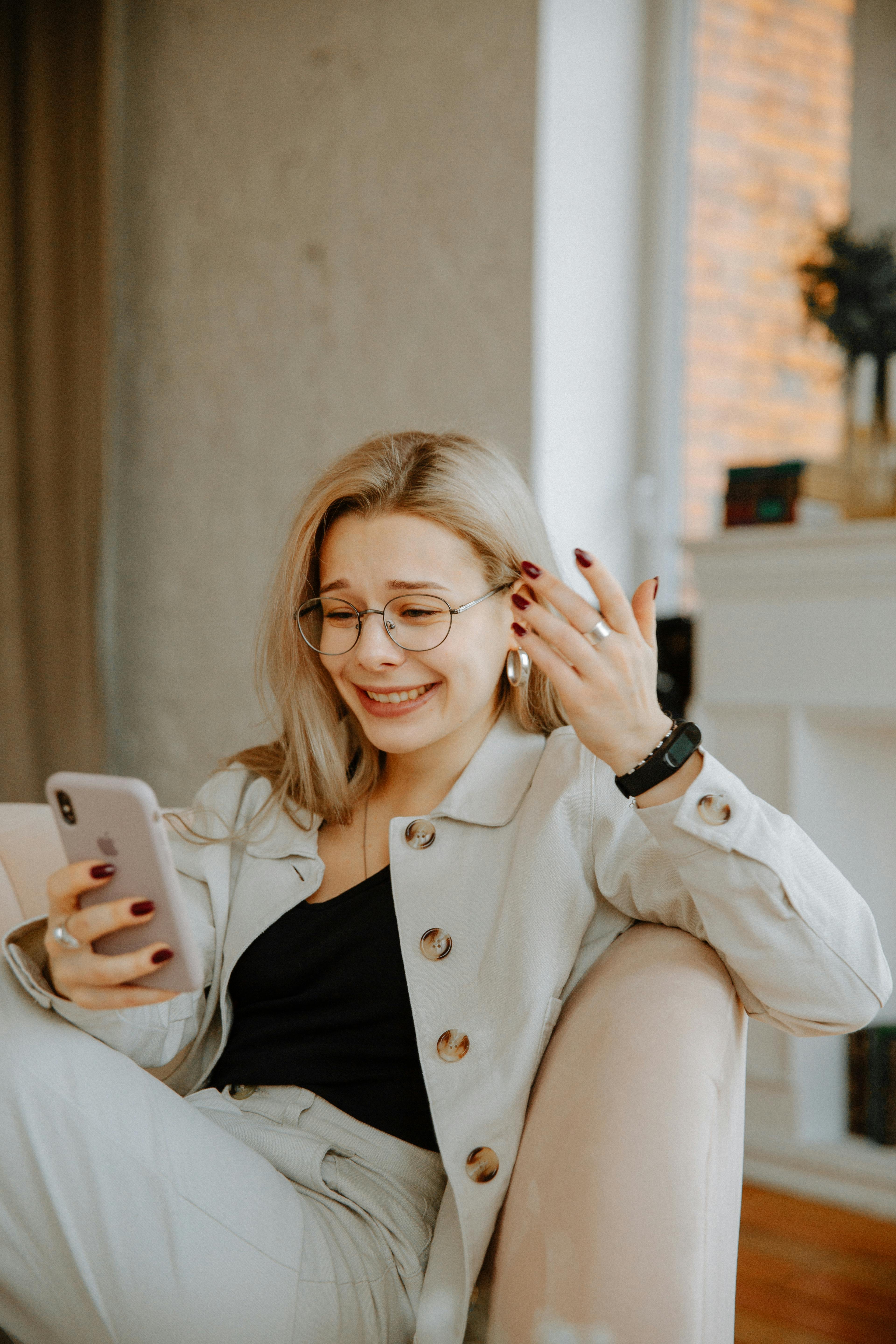 A woman looks confused while holding her phone | Source: Pexels