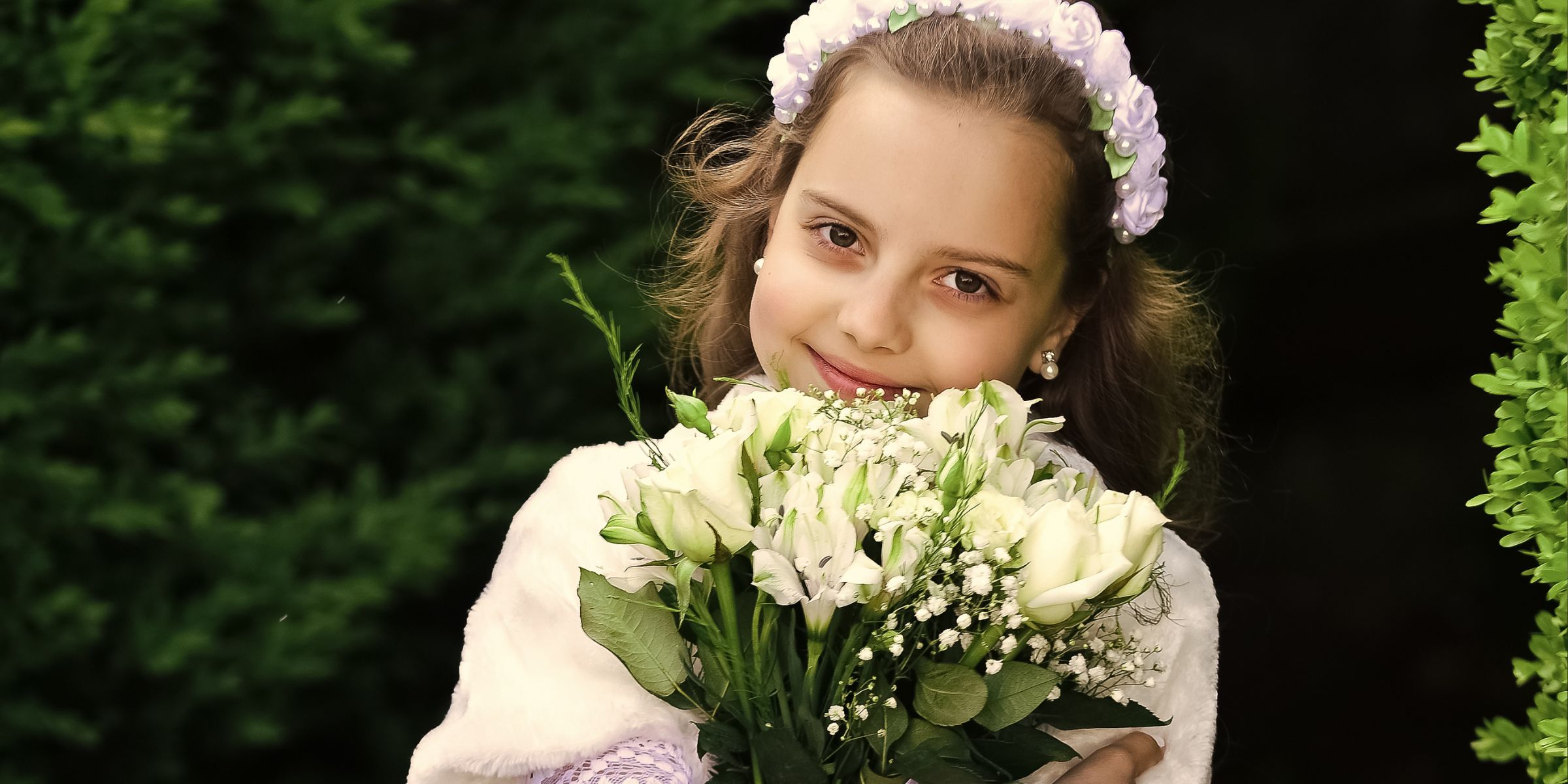 A young girl holding a bouquet | Source: Shutterstock