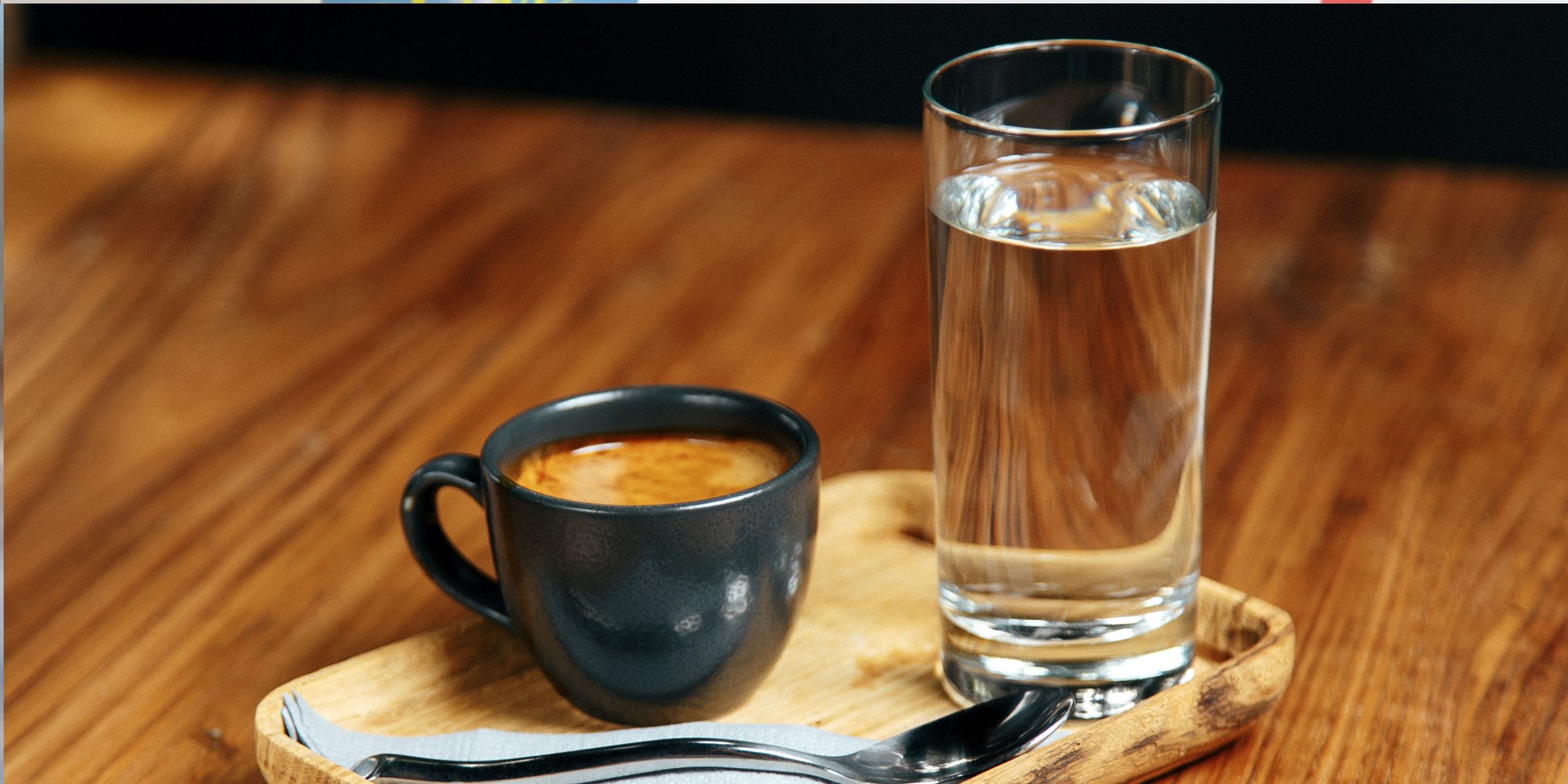 A cup of coffee served with a glass of water | Source: Shutterstock