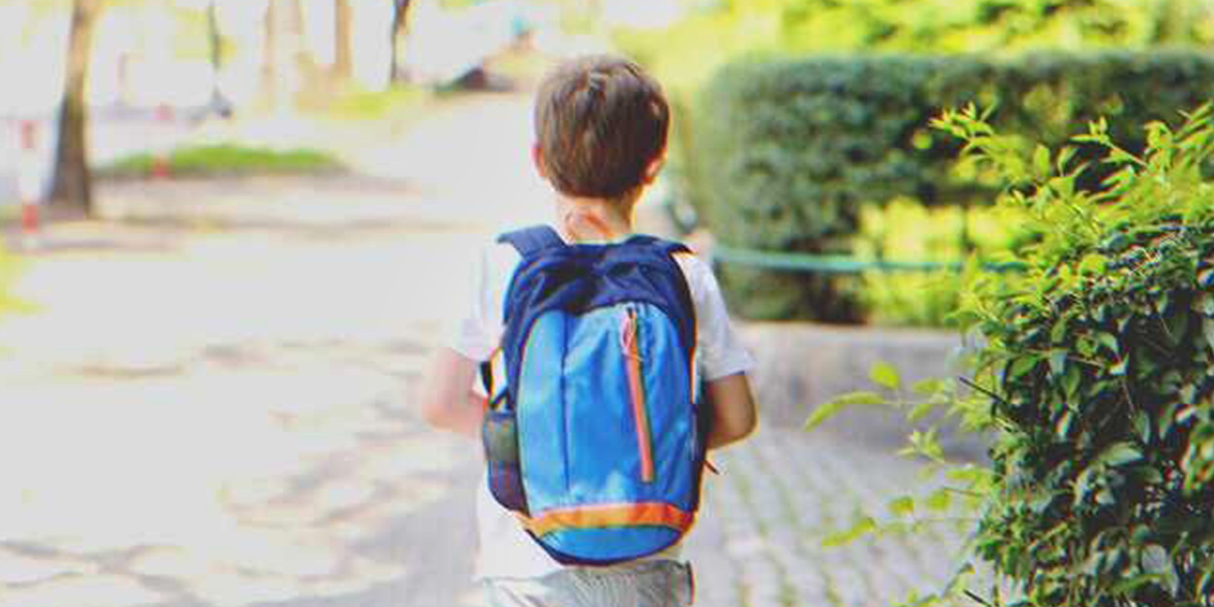 A kid with a backpack walking down the street | Source: Shutterstock