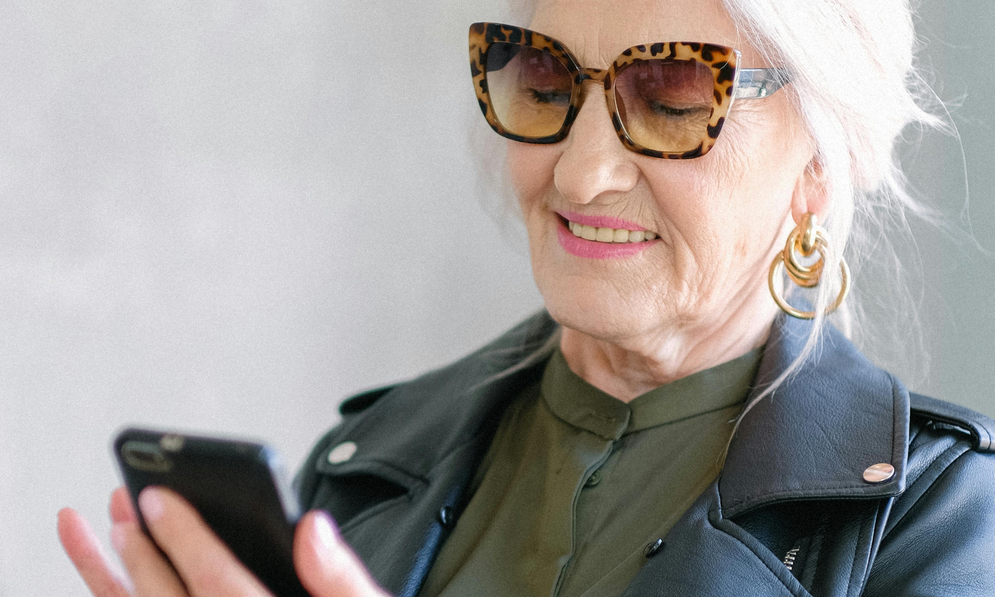 An elderly woman examines a cell phone screen | Source: Pexels