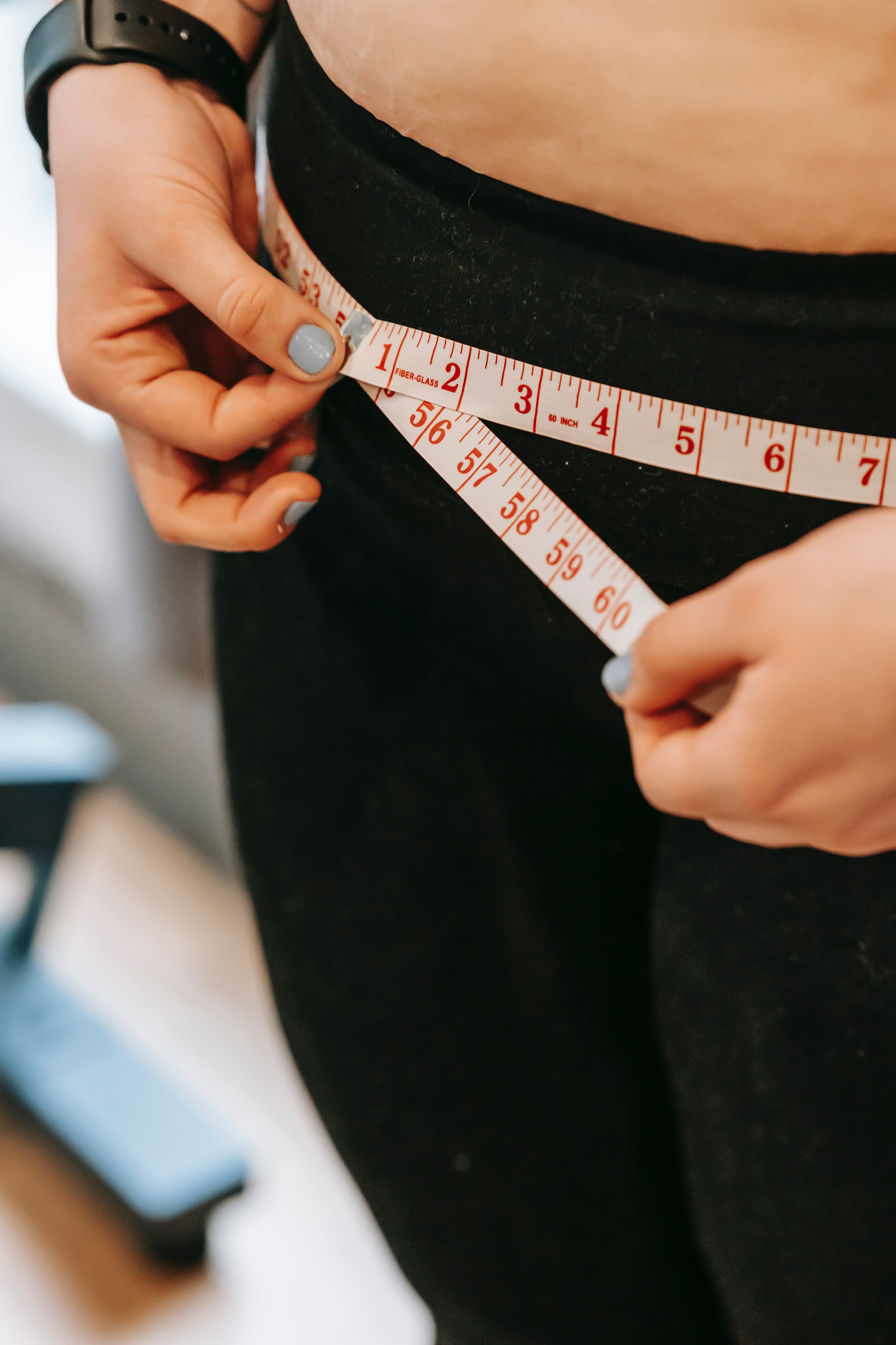 A person taking their body measurements. | Source: Pexels