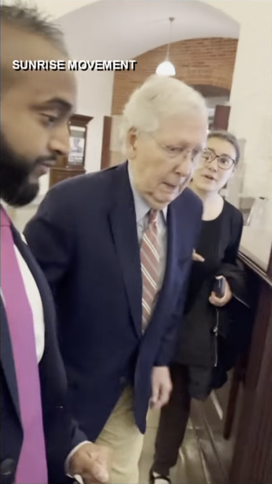Senator Mitch McConnell appears unsteady while gripping his aide's arm, as a woman stands nearby, as posted on October 16, 2025 | Source: YouTube/WHAS11News