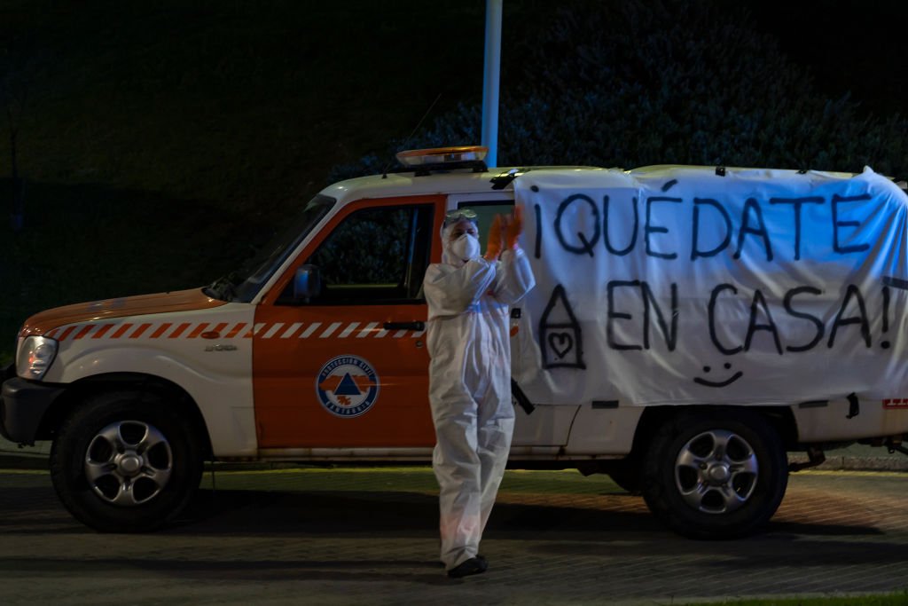 A young woman from Civil Protection applauds at 8 pm in front of her car with the banner Stay at home to encourage them during the mandatory quarantine decreed by the government as a result of the coronavirus (Covid-19) in Santander, Spain, on March 28, 2020. I Foto: Getty Images