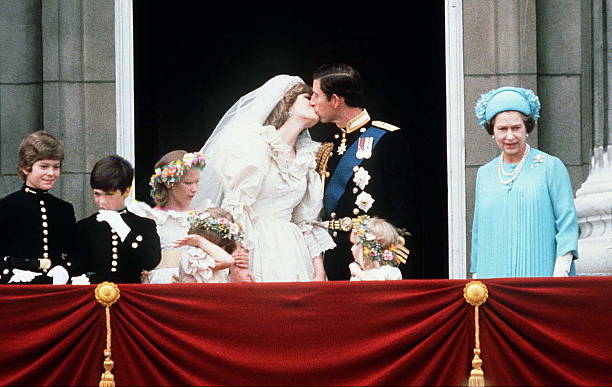Prince Charles And Princess Diana Kissing On The Balcony Of Buckingham Palace On Their Wedding Day. (l To R) Lord Nicholas Windsor, Edward Van Cutsem, Sarah Jane Gaselee, Catherine Cameron, Princess Diana, Prince Charles, Clementine Hambro And Queen Elizabeth II | Photo: Tim Graham Photo Library/Getty Images