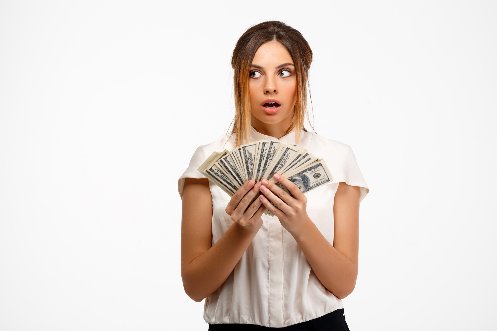 A young woman with a look of surprise while holding money | Source: Freepik