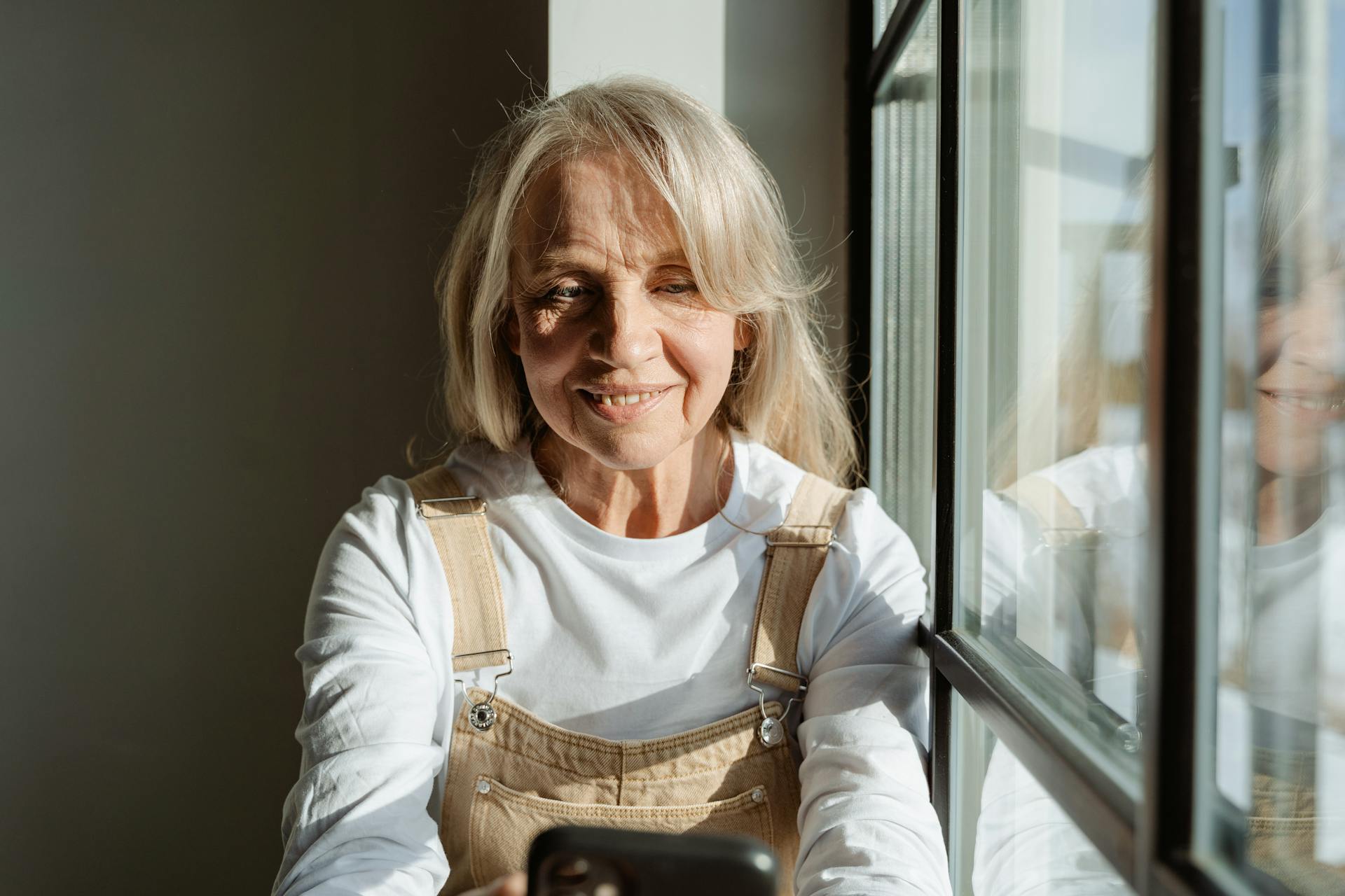 An elderly woman sitting by the window | Source: Pexels