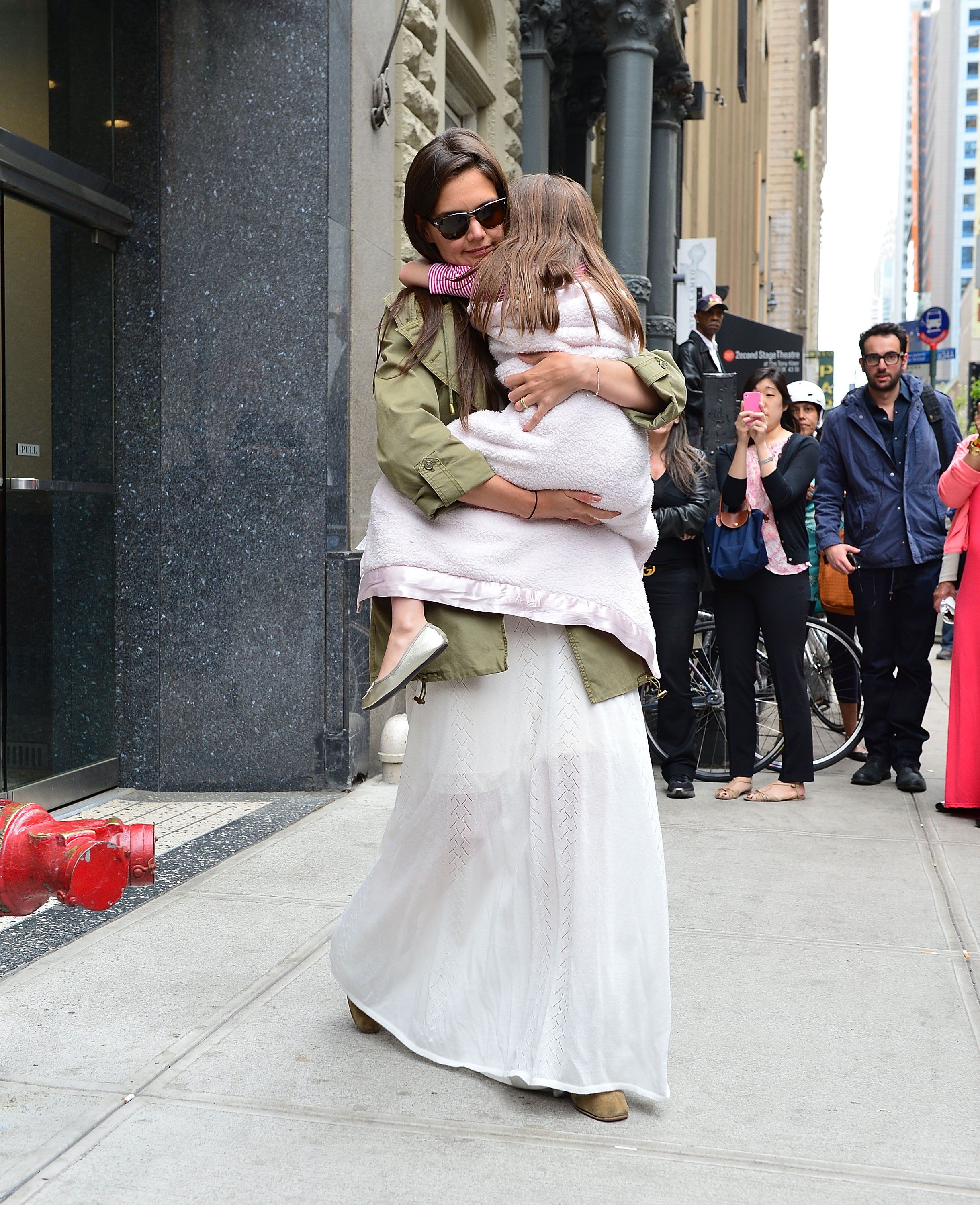 Katie Holmes hugs her daughter Suri Cruise as they walk through Manhattan on April 18, 2012 | Source: Getty Images