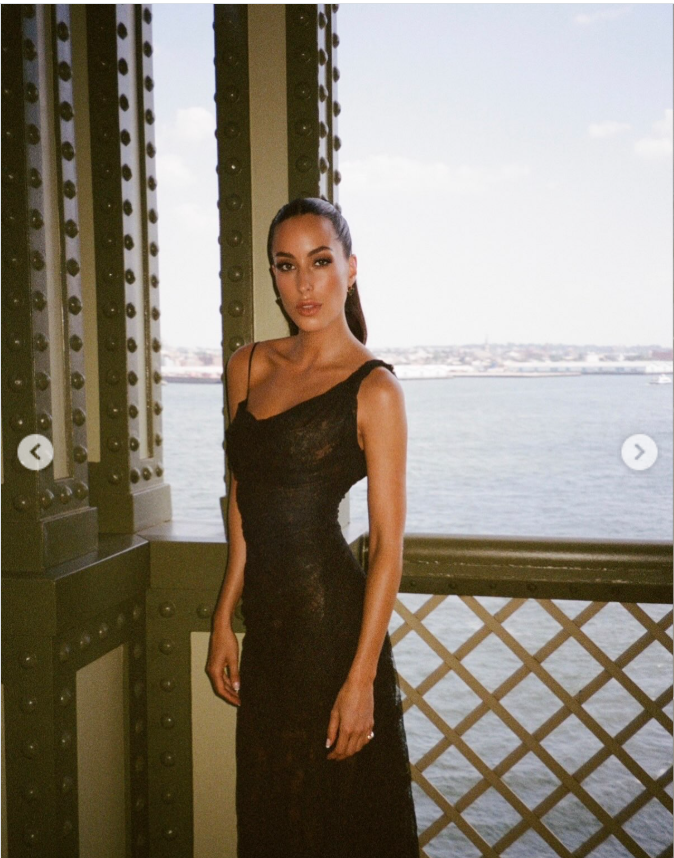 Ines de Ramon posed in her floor-length black gown, showing off its asymmetrical neckline and softly draped silhouette. The wedding guest look later divided commenters, with some praising its polished elegance and others questioning whether it was appropriate for the occasion. | Source: Instagram/lauriezanoletti