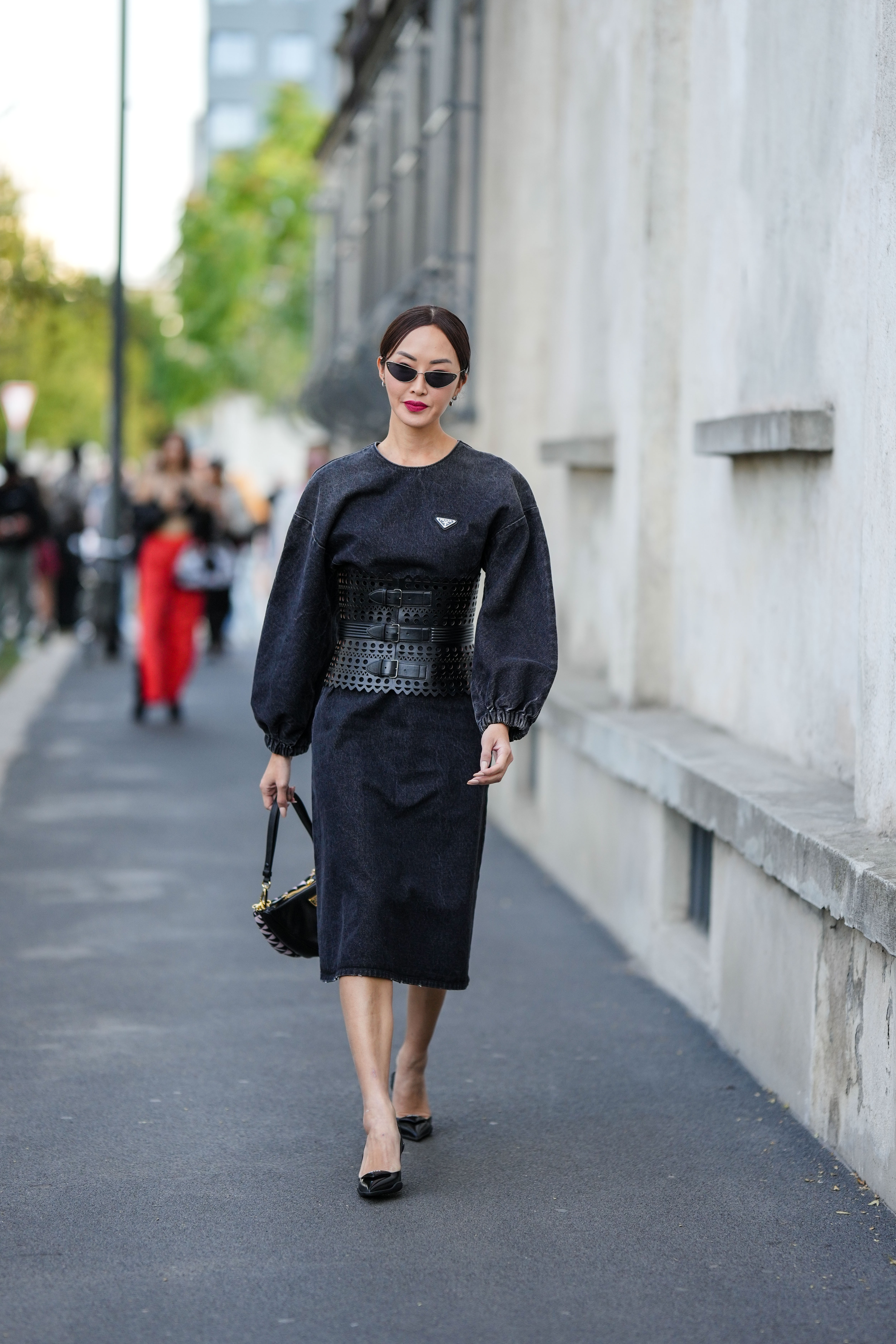 Chriselle Lim wearing a black corset on a black denim long sleeves dress during the Milan Fashion Week on September 22, 2022, in Milan | Source: Getty Images