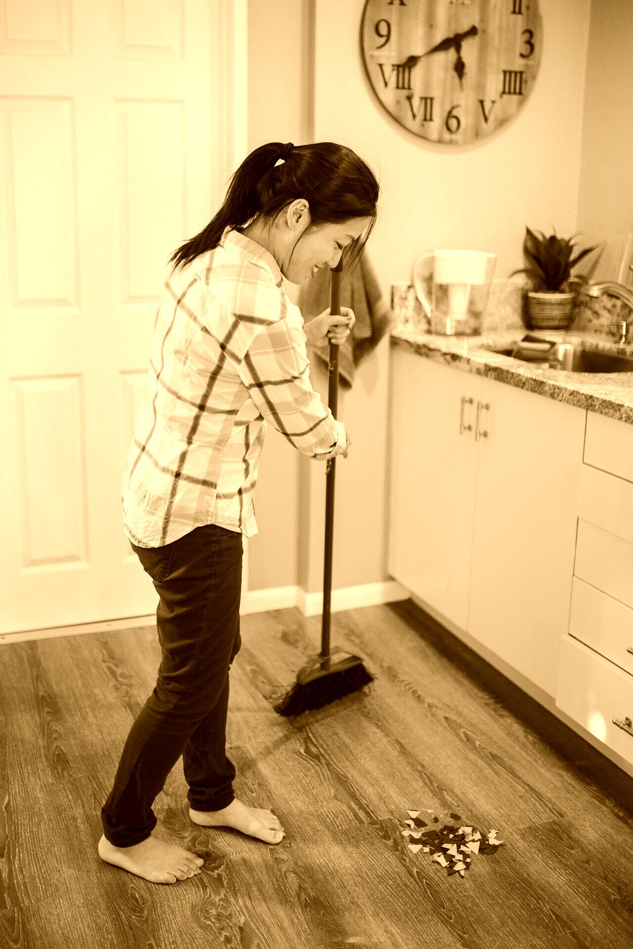 Una joven mujer limpia los pisos con un cepillo. | Foto: Pexels