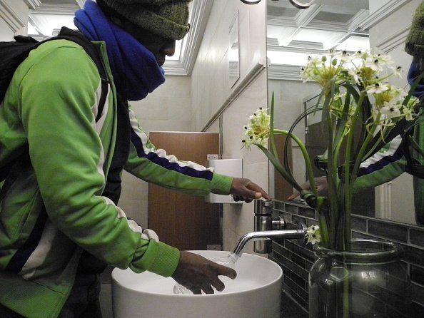 A man pictured using the tap in the restroom | Photo: Getty Images