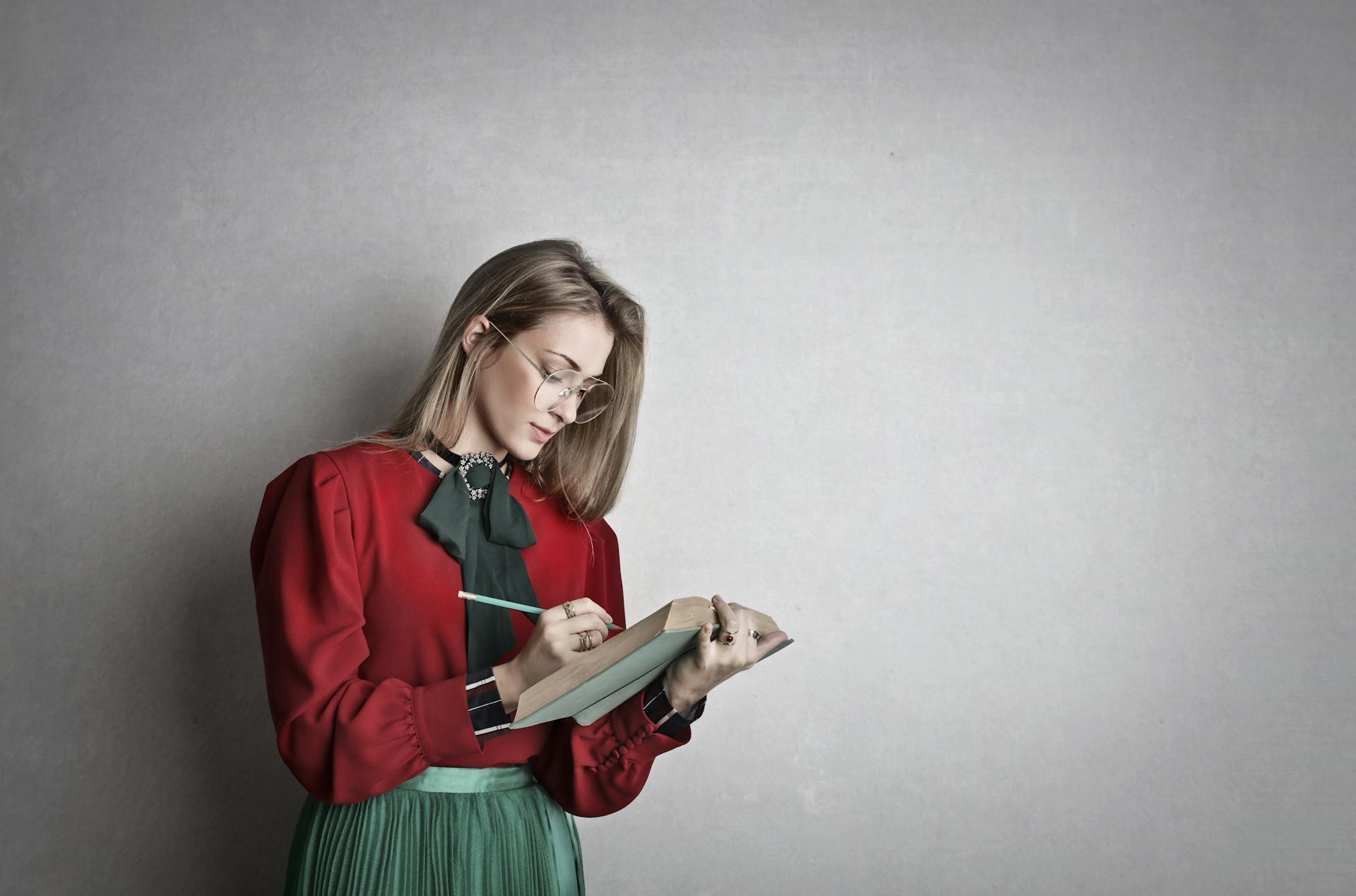 A woman making notes in a book | Source: Pexels