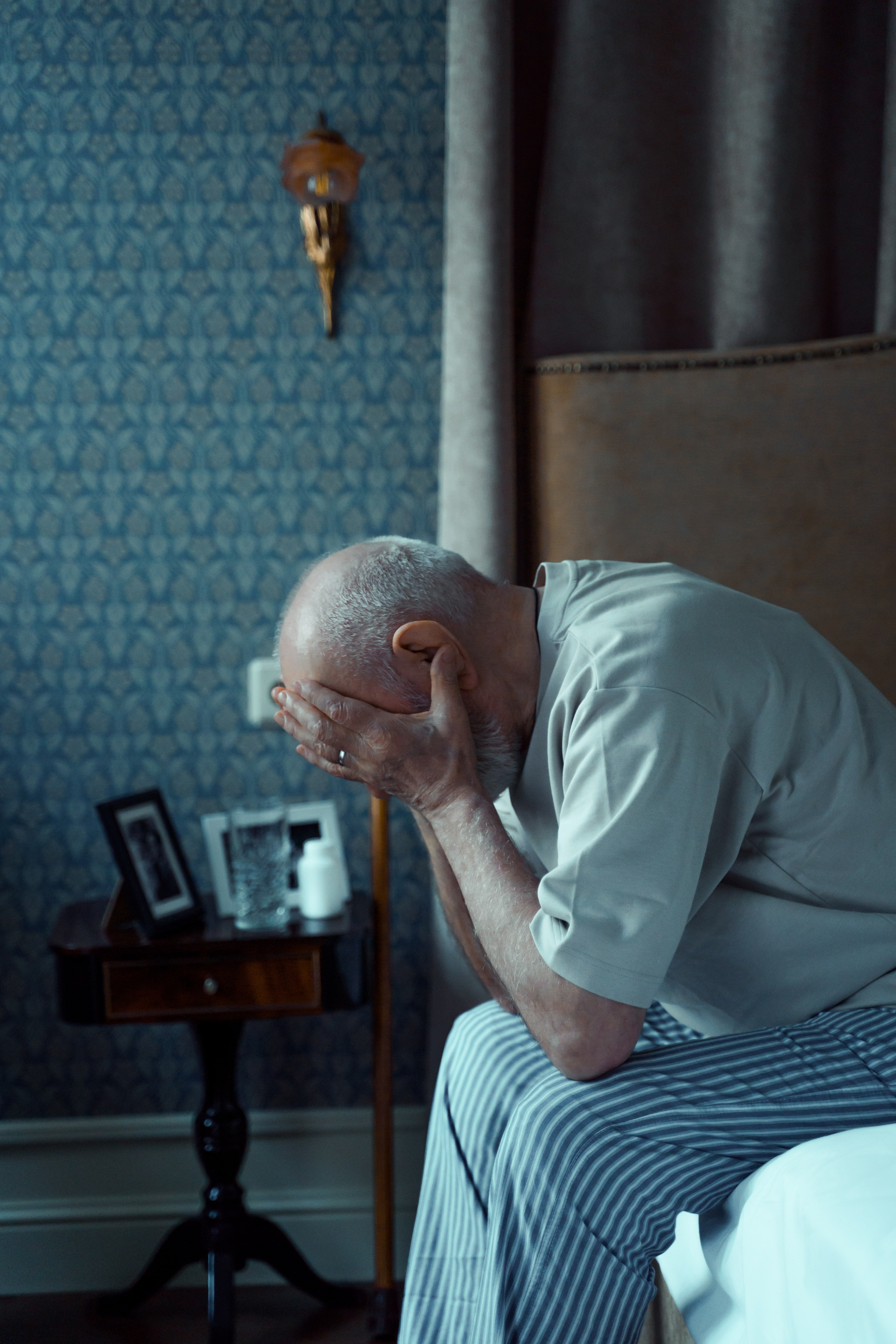 Hombre mayor afligido sentado en una cama. | Foto: Pexels 