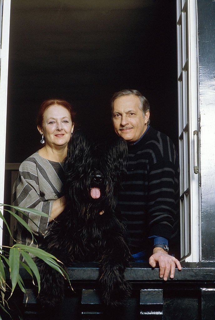 Michel SERRAULT et son épouse Juanita posent à une fenêtre de leur maison de Neuilly. | Photo : Getty Images