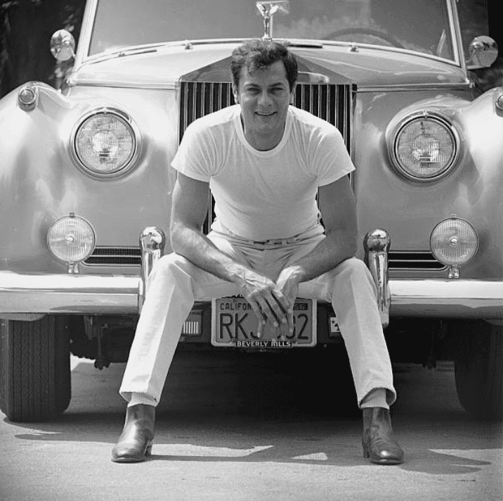 Tony Curtis sitting in front of his Rolls Royce, in 1961, Los Angeles, California | Source: Getty Images (Photo by Ralph Crane/The LIFE Picture Collection)