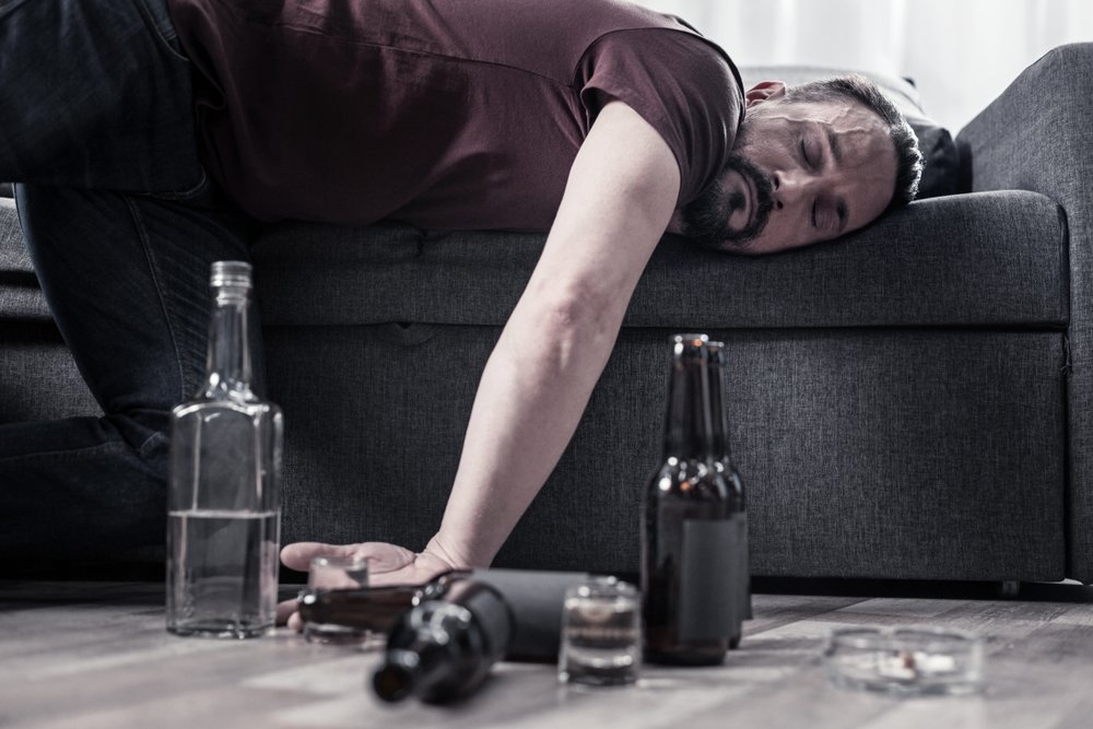 A drunk bearded adult man lying on the sofa and sleeping. | Photo: Shutterstock