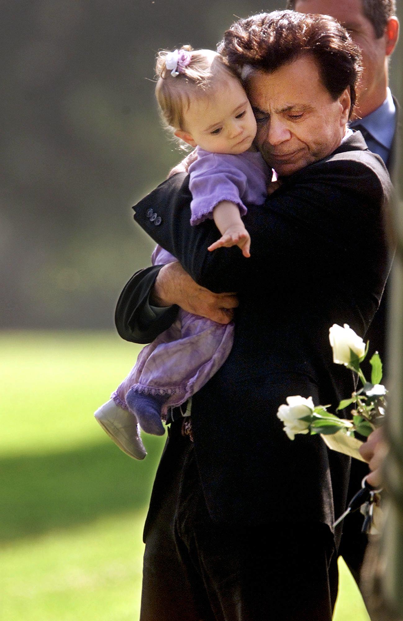 Actor Robert Blake, hugs his 11-month-old daugther Rose Lenore Sophie Blake, during a brief funeral ceremony of his wife Bonny Lee Bakley in Los Angeles, May 25, 2001 | Source: Getty Images