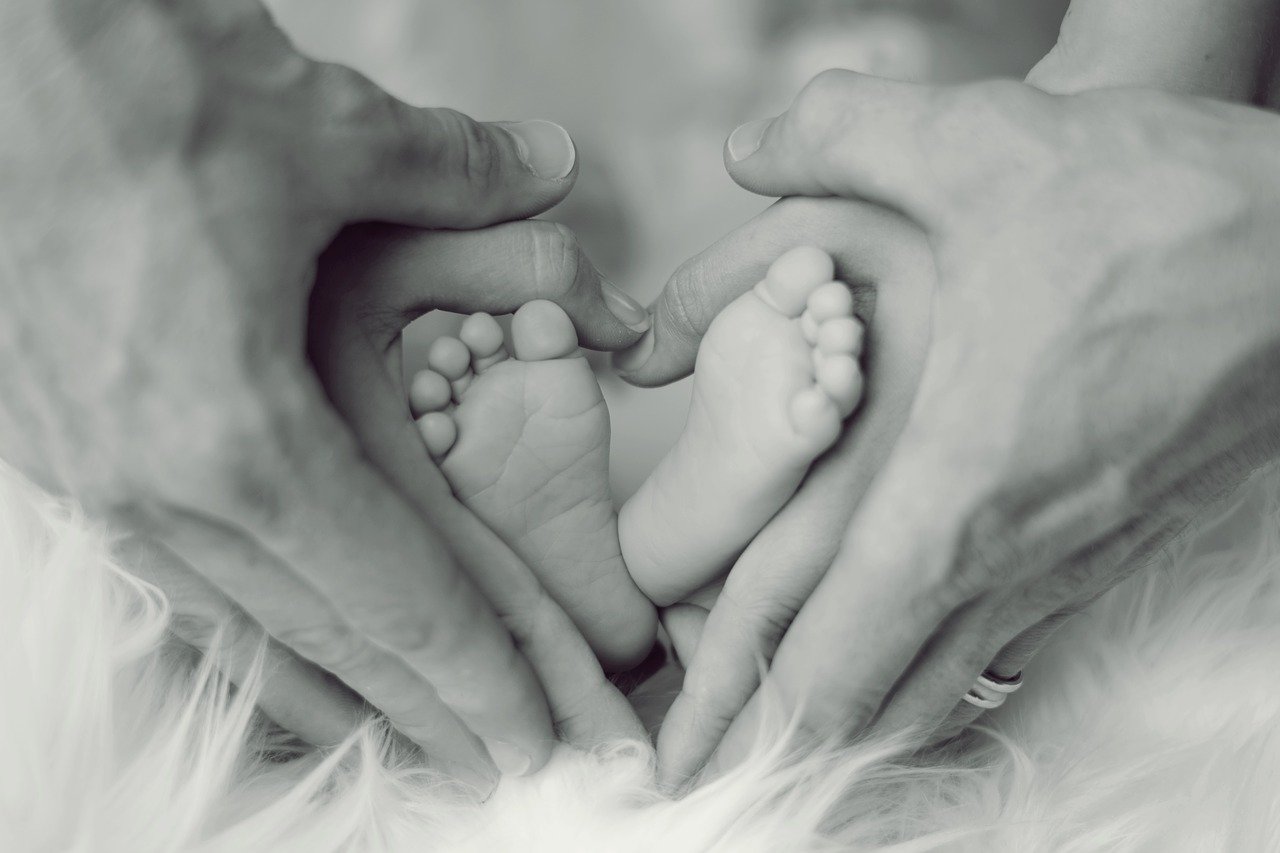 Pies de bebé rodeado de las manos de sus padres. | Foto: Pixabay