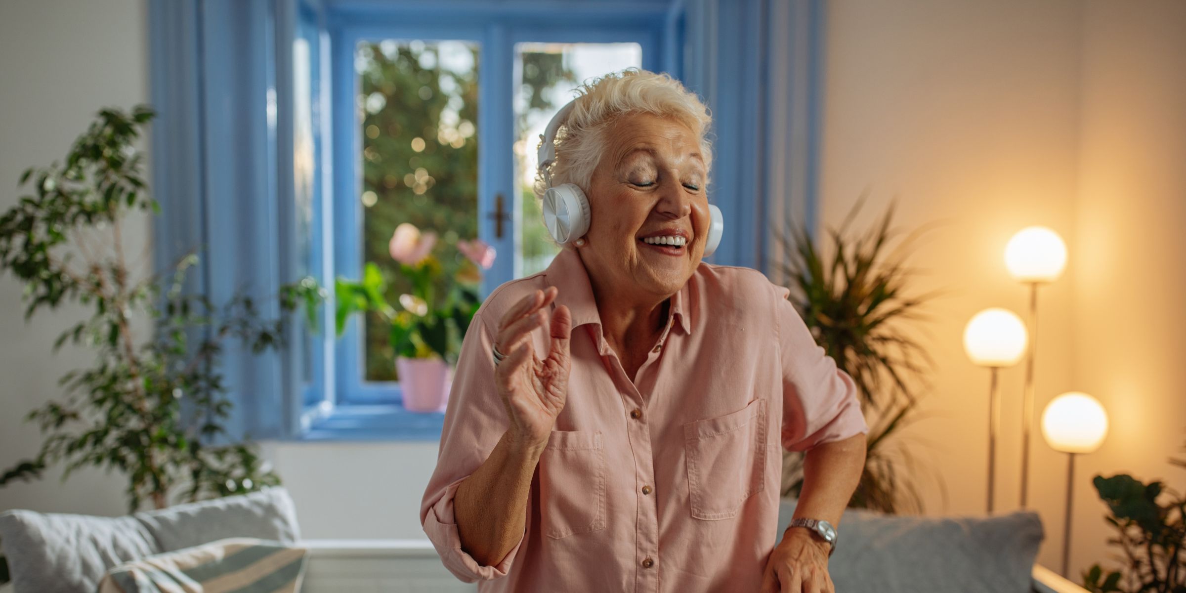 An elderly woman dancing with headphones on | Source: Shutterstock