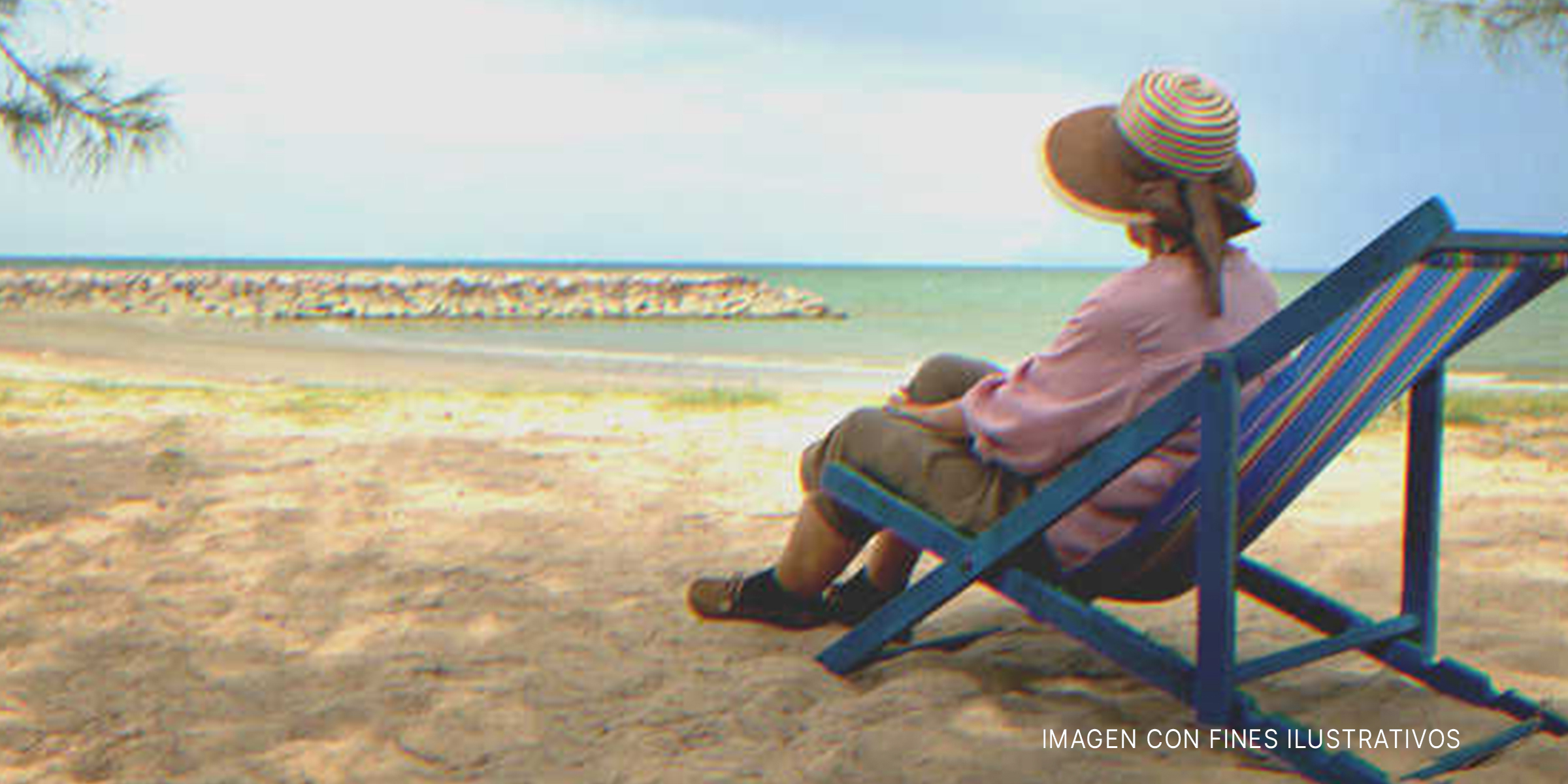 Mujer mayor sentada frente a una playa. | Foto: Shutterstock
