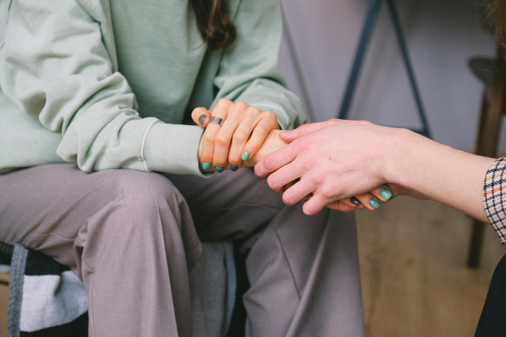 A woman holding her friend's hand | Source: Pexels