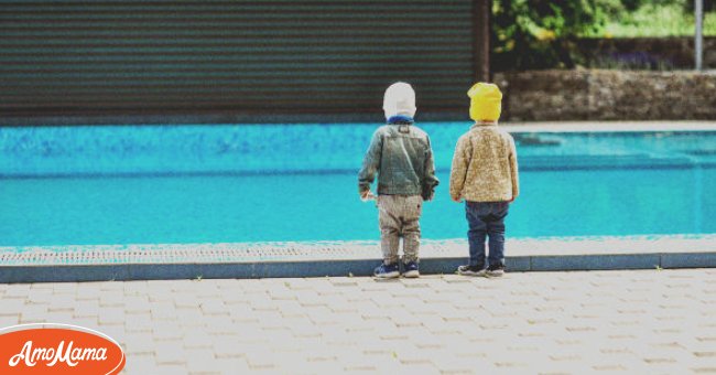Two small girls by the poolside | Photo: Shutterstock