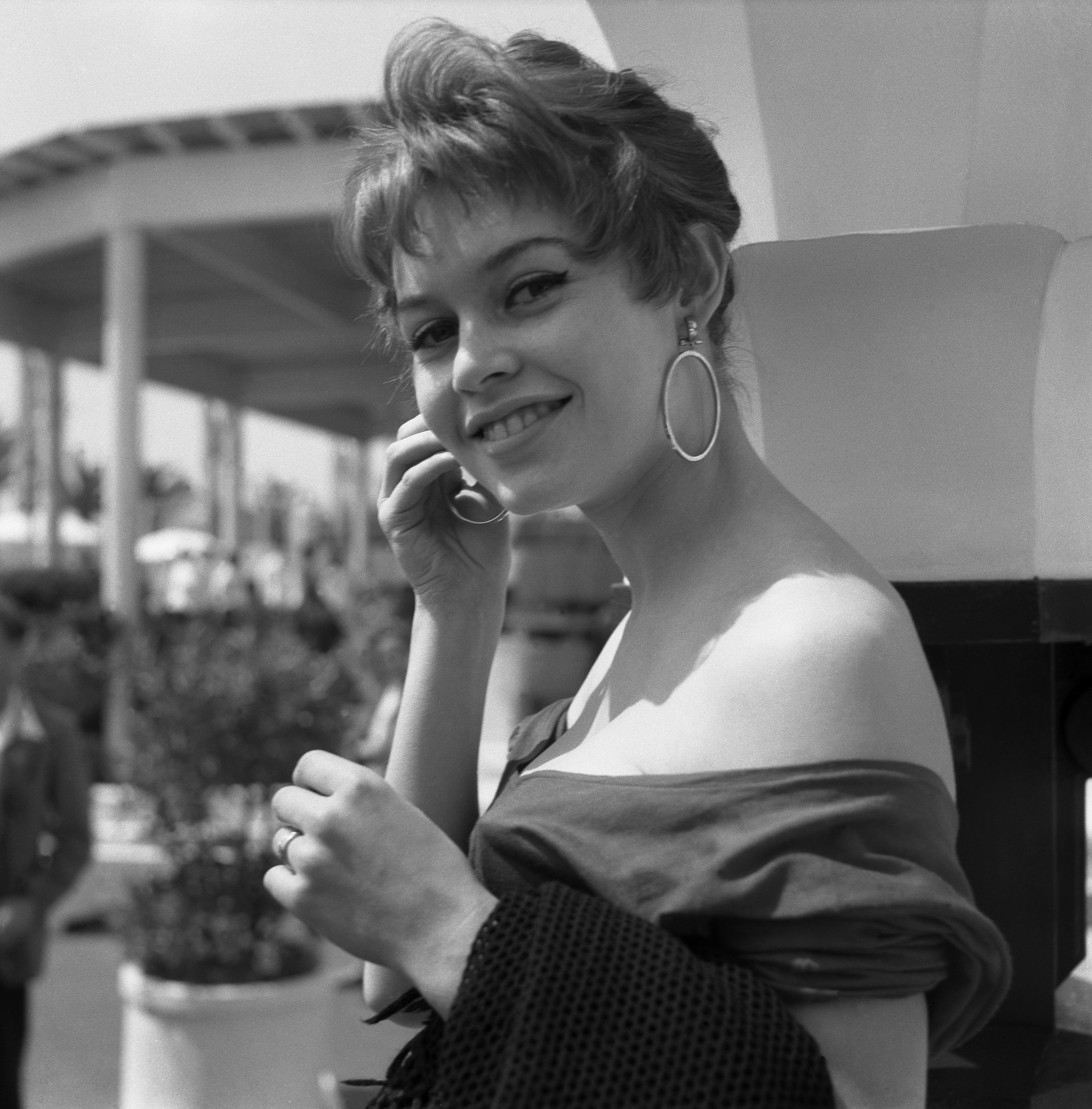 Brigitte Bard portant une chemise nue et de boucles d'oreilles rondes, Cannes, 1955. | Photo : GettyImage Brigitte Bard portant une chemise nue et de boucles d'oreilles rondes, Cannes, 1955. | Photo : GettyImage