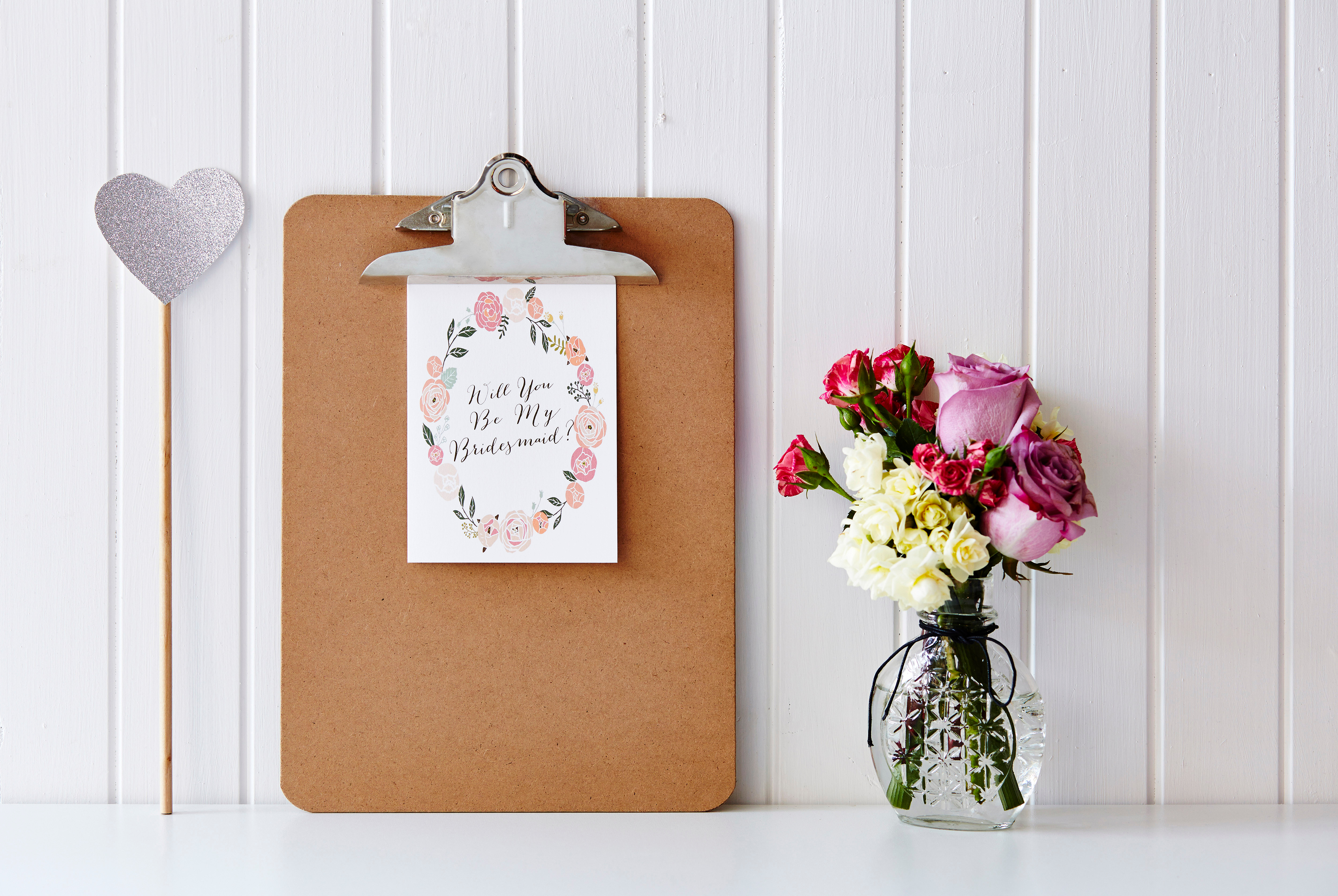 A clipboard containing a bridesmaid card | Source: Shutterstock