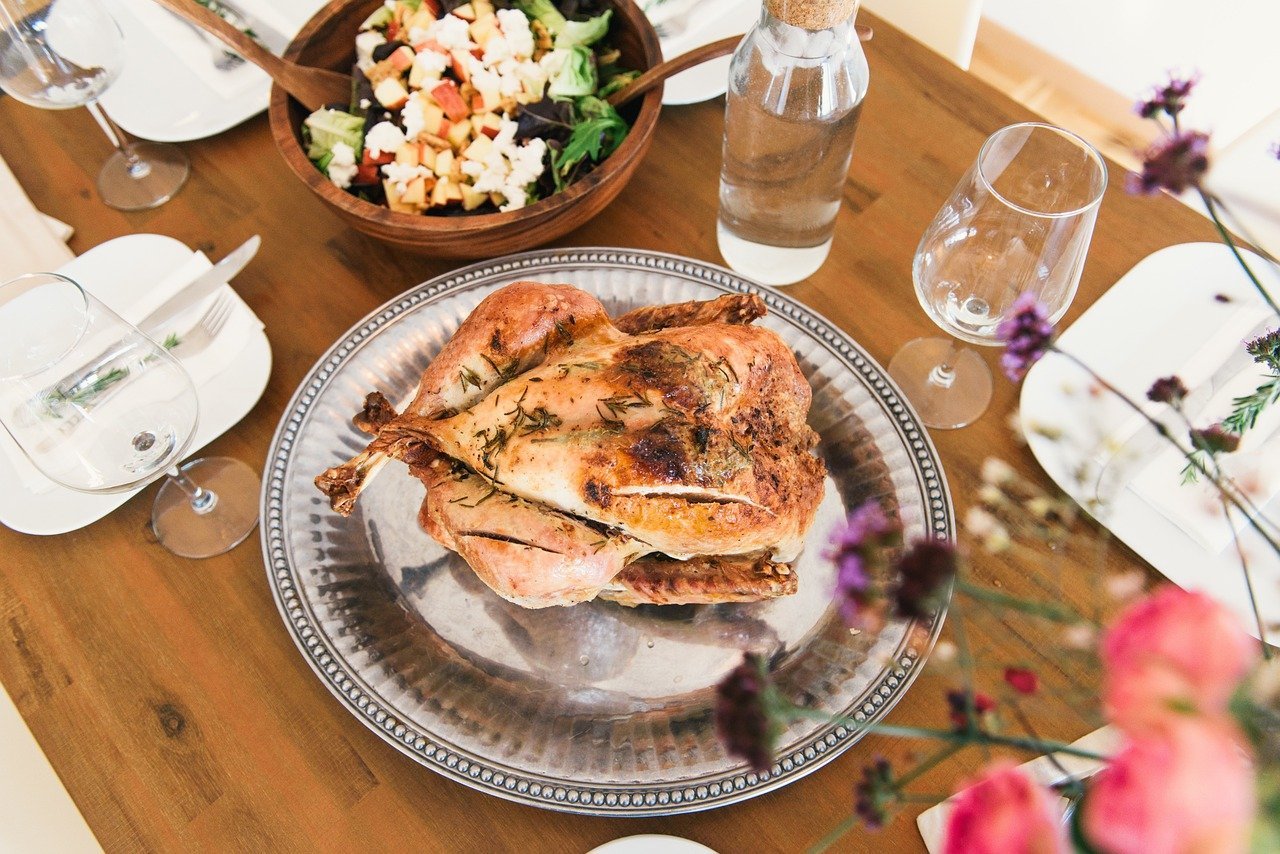 A decked out dining table with a roasted chicken in the center | Photo: Pixabay/Free-Photos