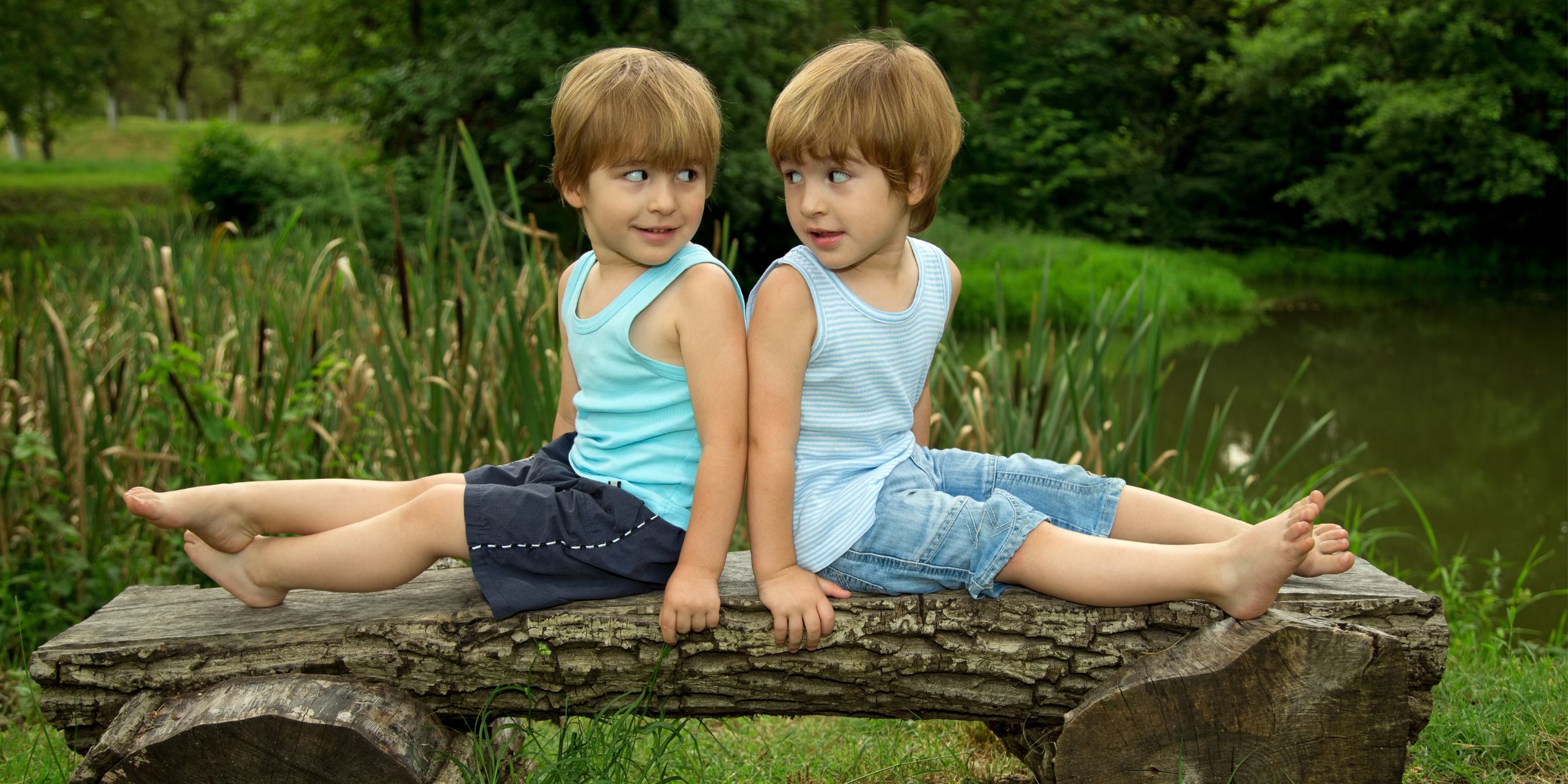 Twin brothers sitting on a bench | Source: Shutterstock