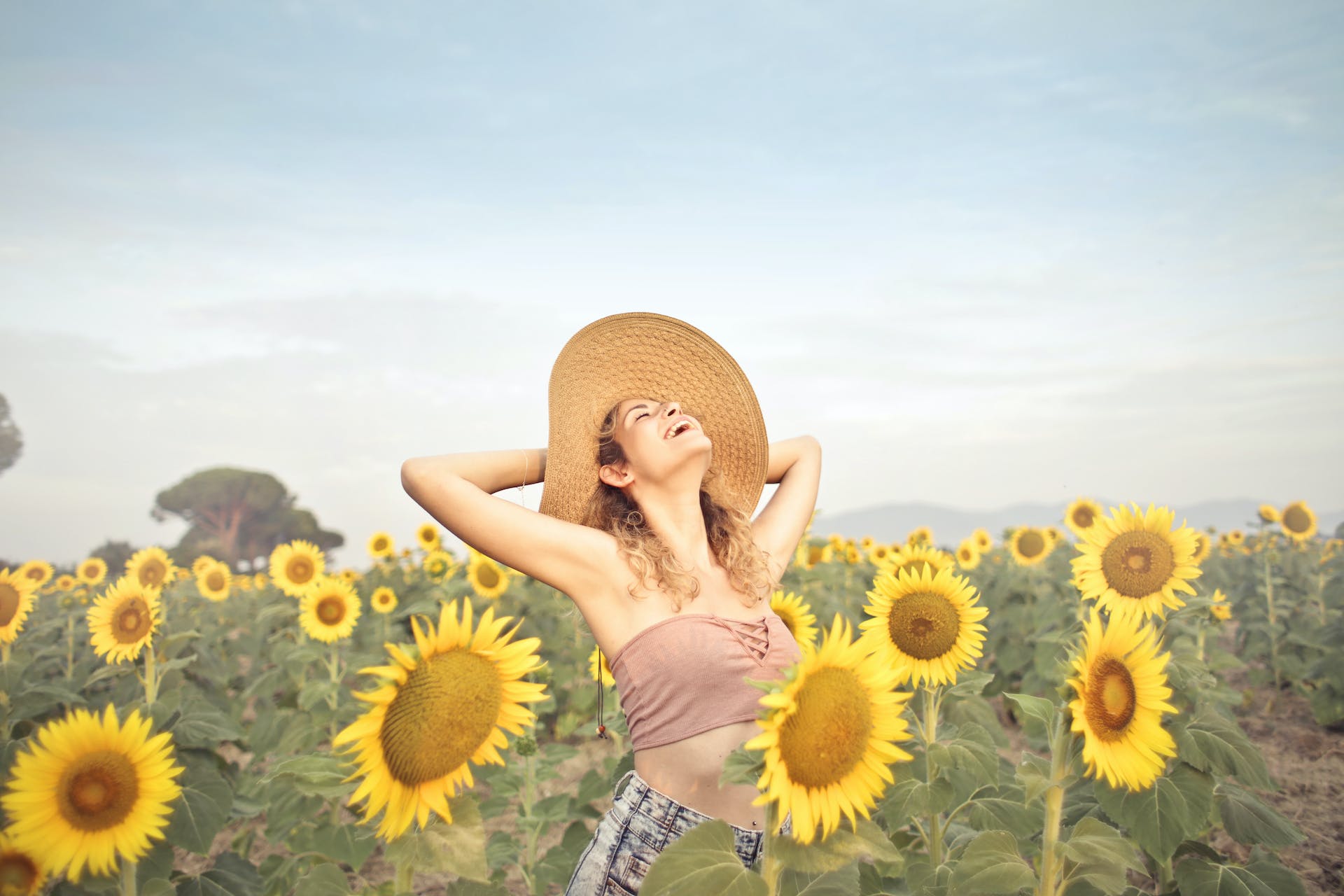Happy woman standing in a sunflower field | Source: Pexels
