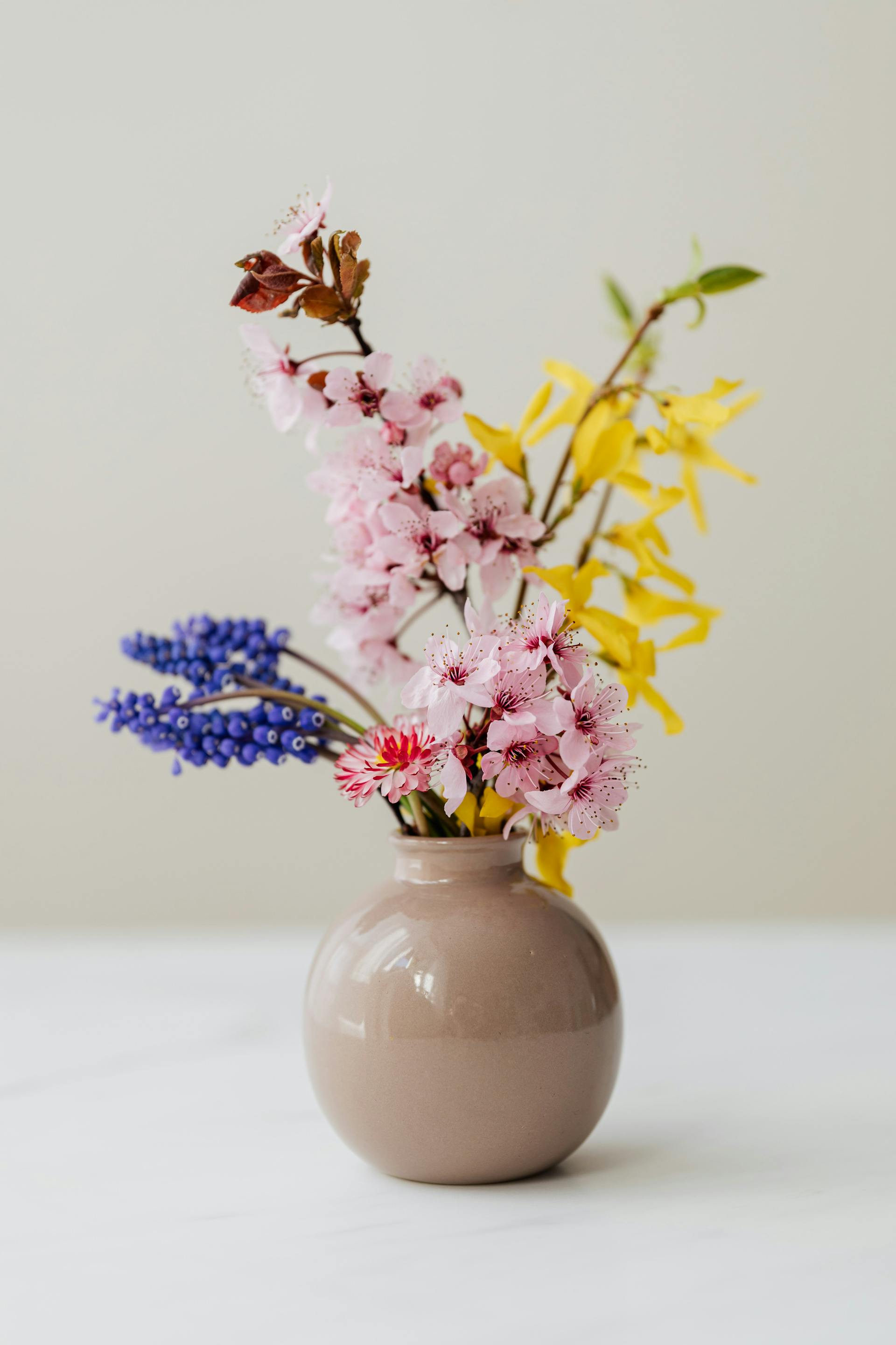 A photo of flowers in a ceramic vase lying on a table | Source: Pexels