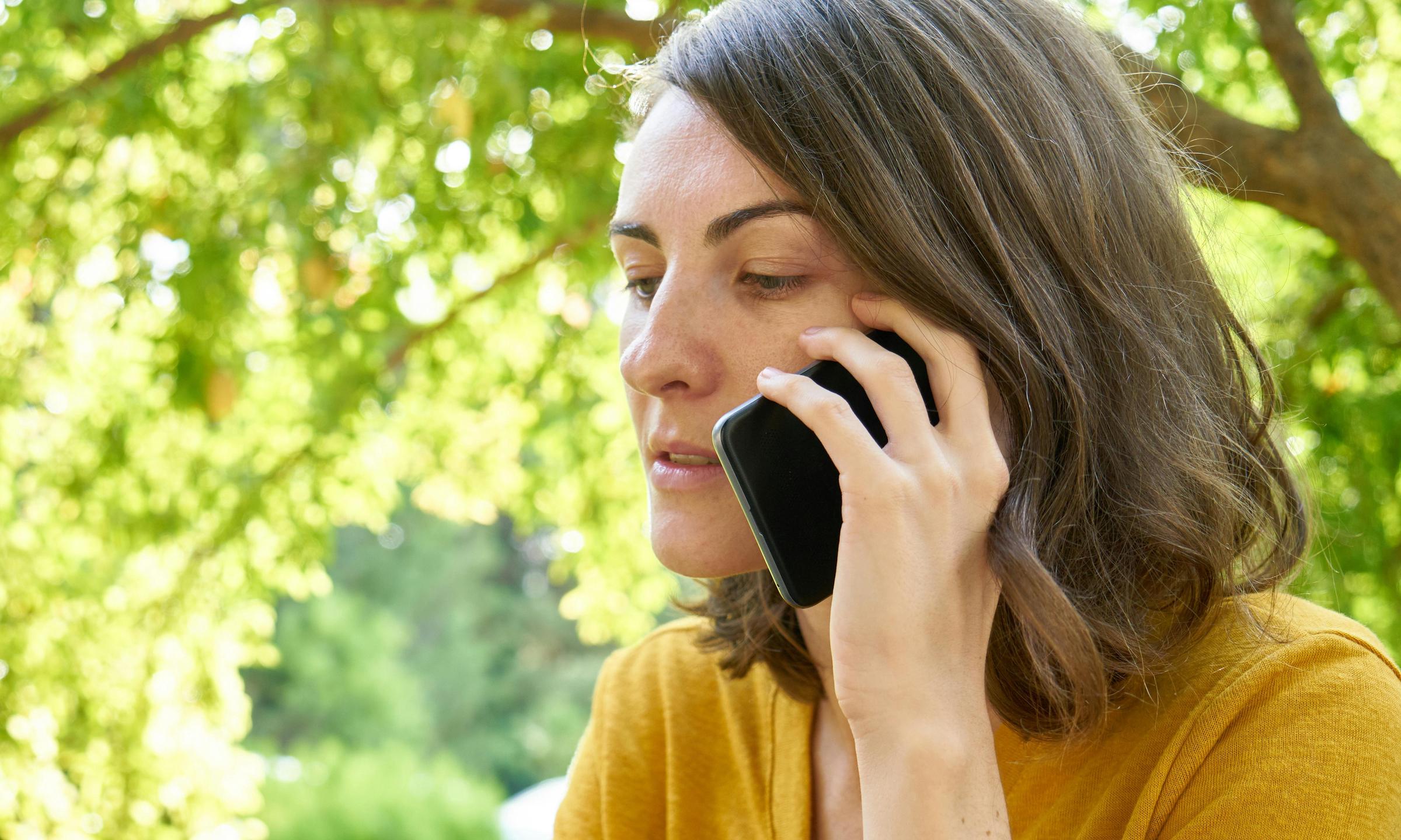 A woman making a call on a cell phone outdoors | Source: Pexels