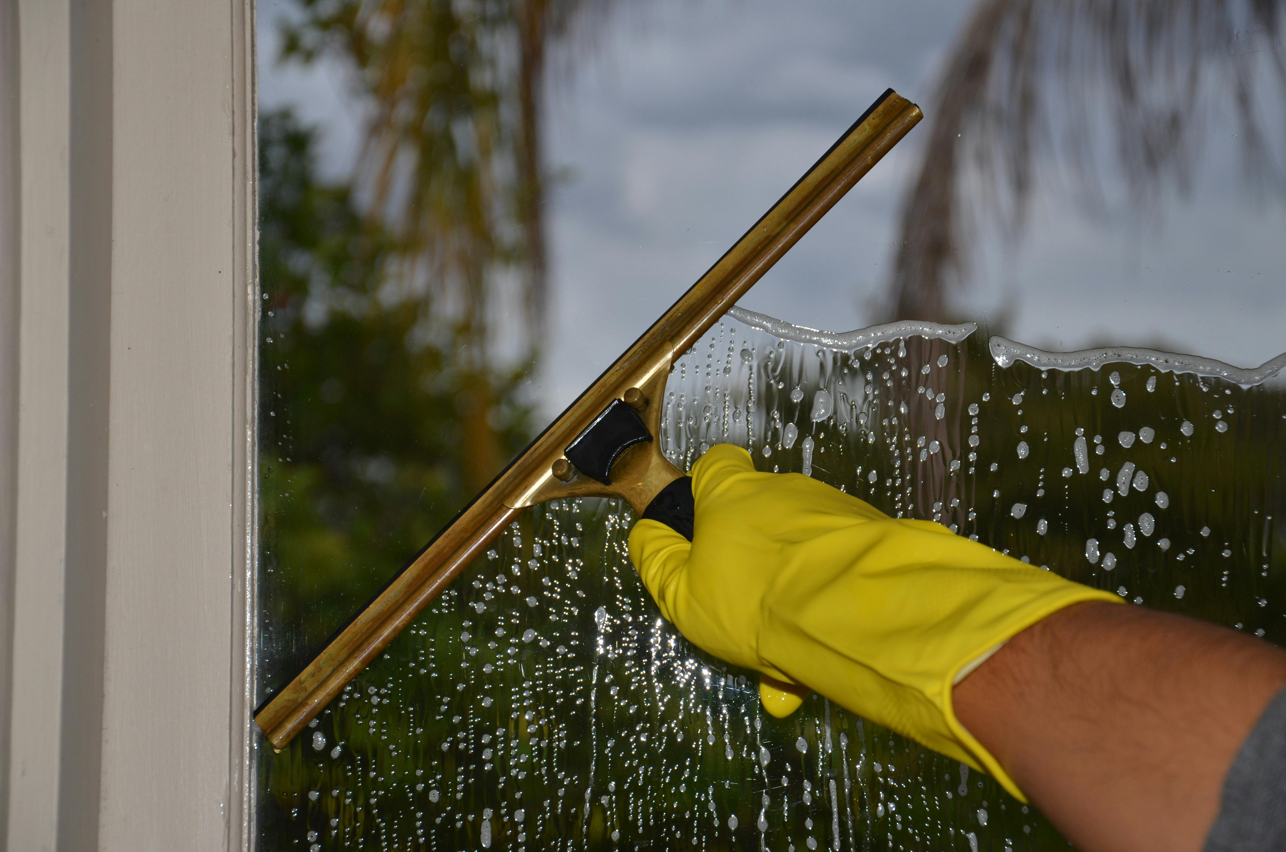 Using a squeegee to clean a glass surface | Source: Pexels