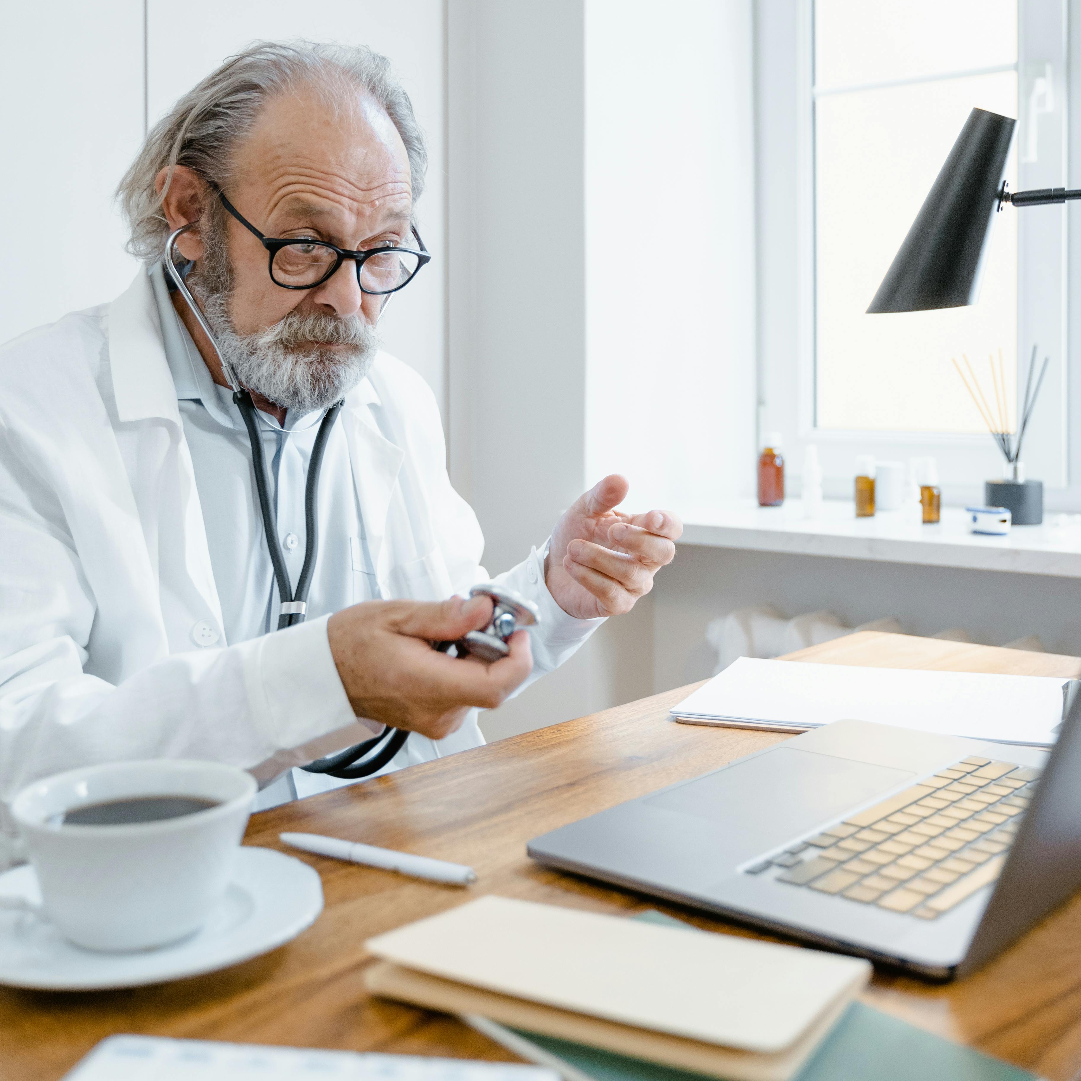 A doctor behind his desk making a hand gesture | Source: Pexels