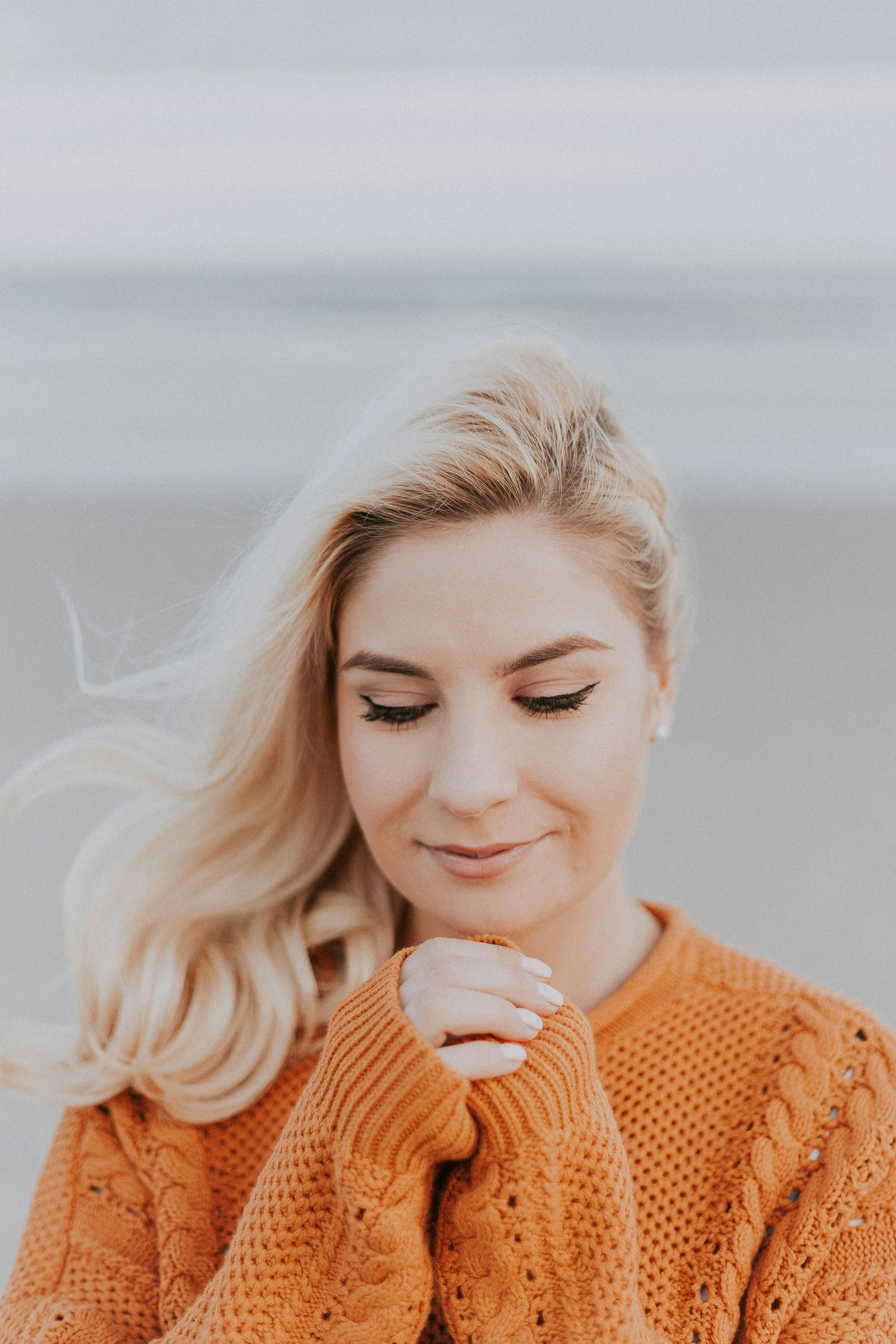 Blonde-haired woman in orange knit long-sleeved top | Source: Pexels